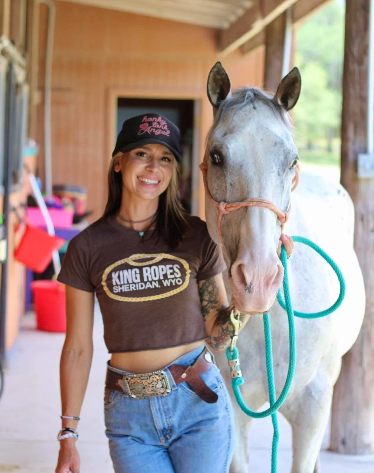 Morgan at The Gentle Cowgirl in Stockdale, TX smiling with a white horse — offering riding lessons, boarding, and horse training in the San Antonio area