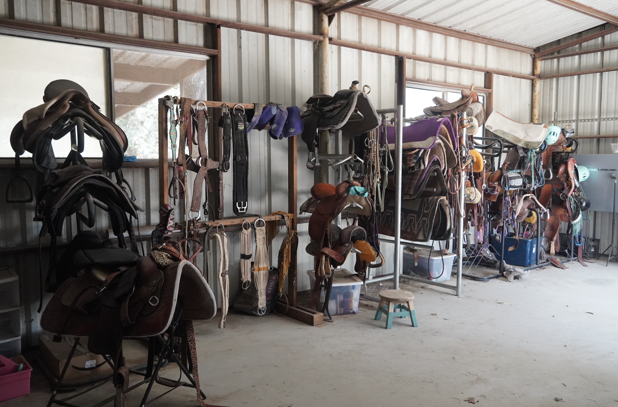 Tack room filled with western saddles, bridles, and riding equipment at The Gentle Cowgirl in Stockdale, TX — full service horse boarding and riding facility near San Antonio