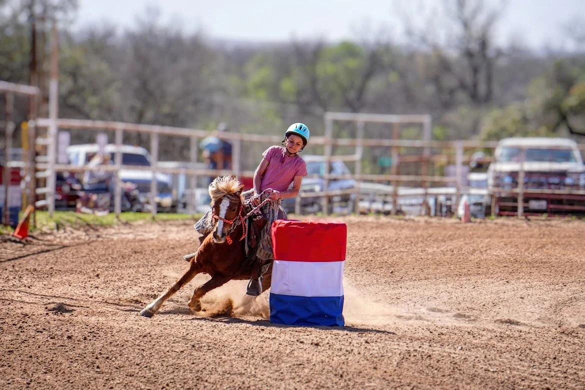 Young rider barrel racing on a pony at The Gentle Cowgirl in Stockdale, TX — western riding lessons and performance training for kids near San Antonio