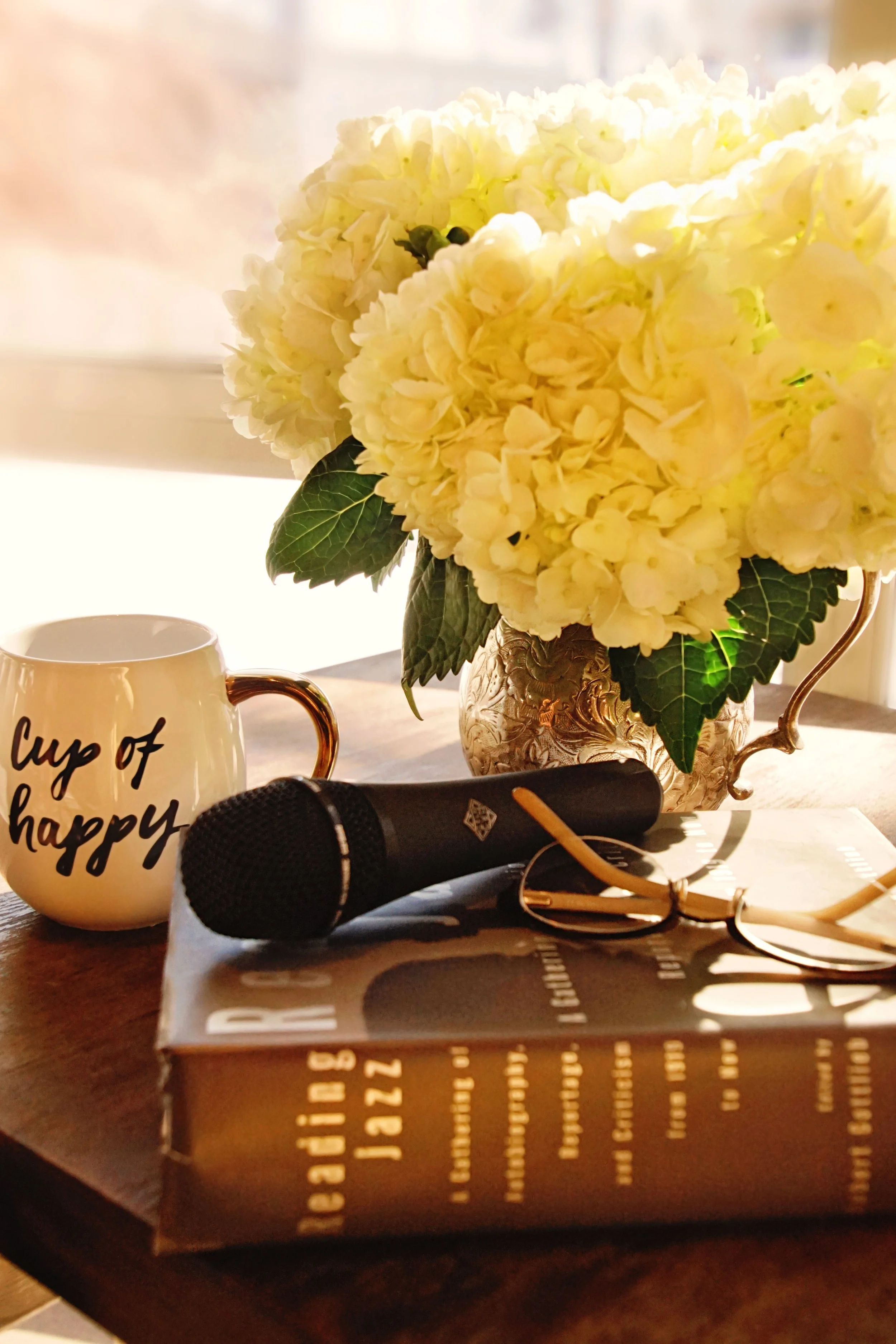 A bouquet of white flowers and glasses sitting on top of a book