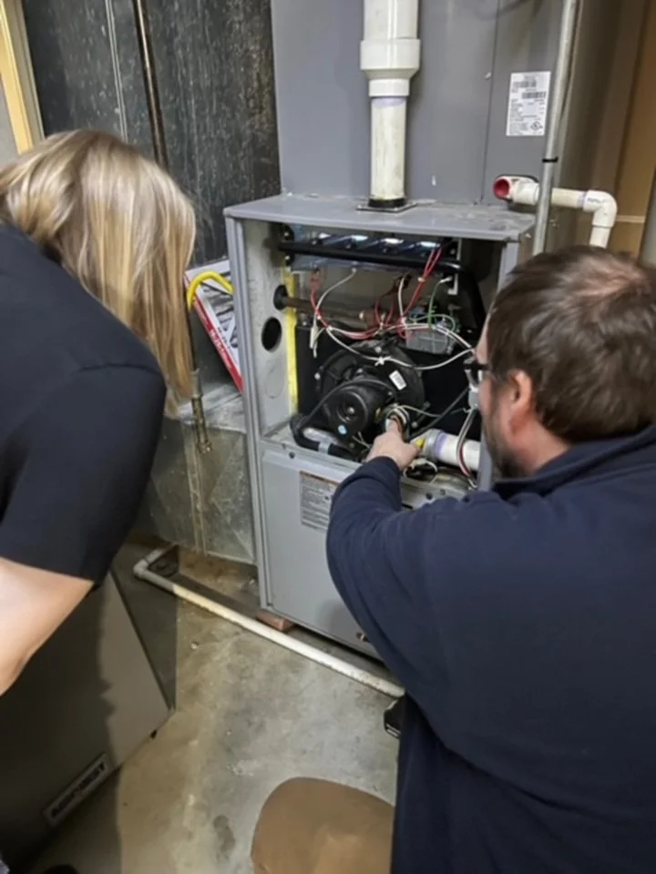 Lair Mechanical technician and customer review a furnace unit to ensure the client understands the diagnostic issue causing heating problems throughout their home in Bethalto, IL.