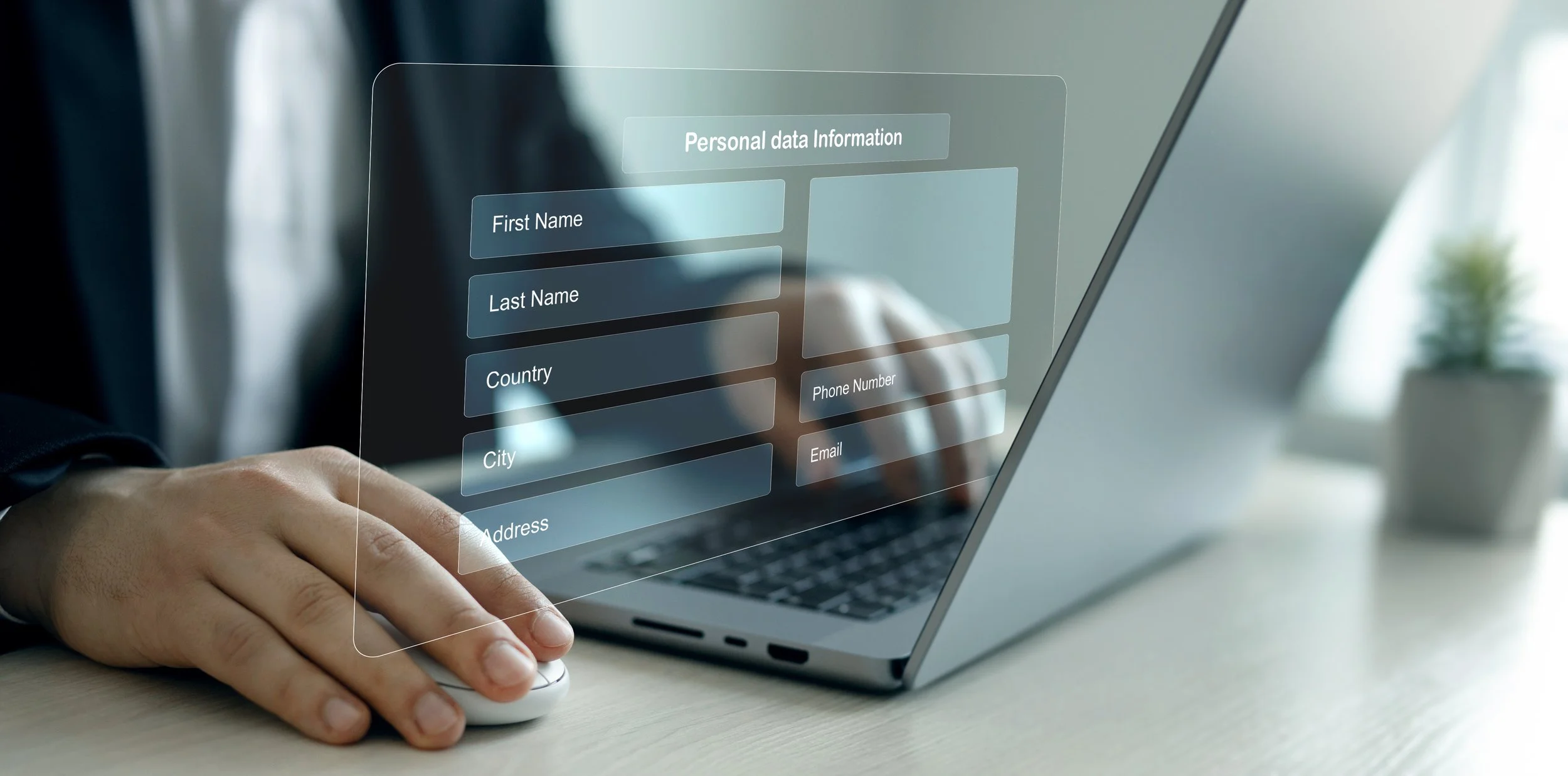A person uses a computer mouse to interact with a transparent digital form displayed on a laptop screen, which contains fields for personal data information such as first name, last name, country, city, address, phone number, and email.