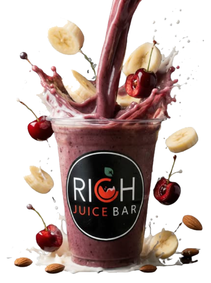 A berry smoothie in a clear cup with a black logo reading 'RICH Juice Bar.' Fresh banana, cherry, and almond pieces are falling into the smoothie, with some splashing out.