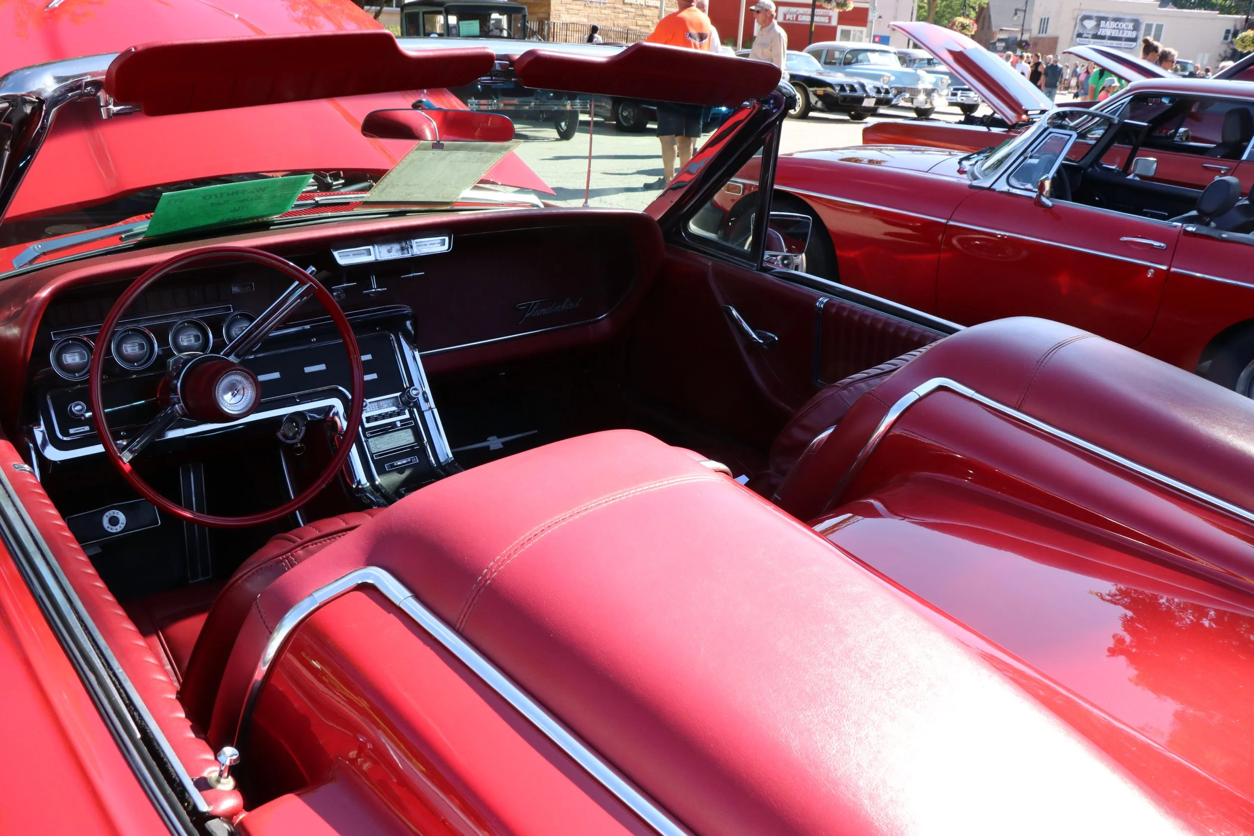 Red interior and steering wheel of a classic red car being shown at WAMBO