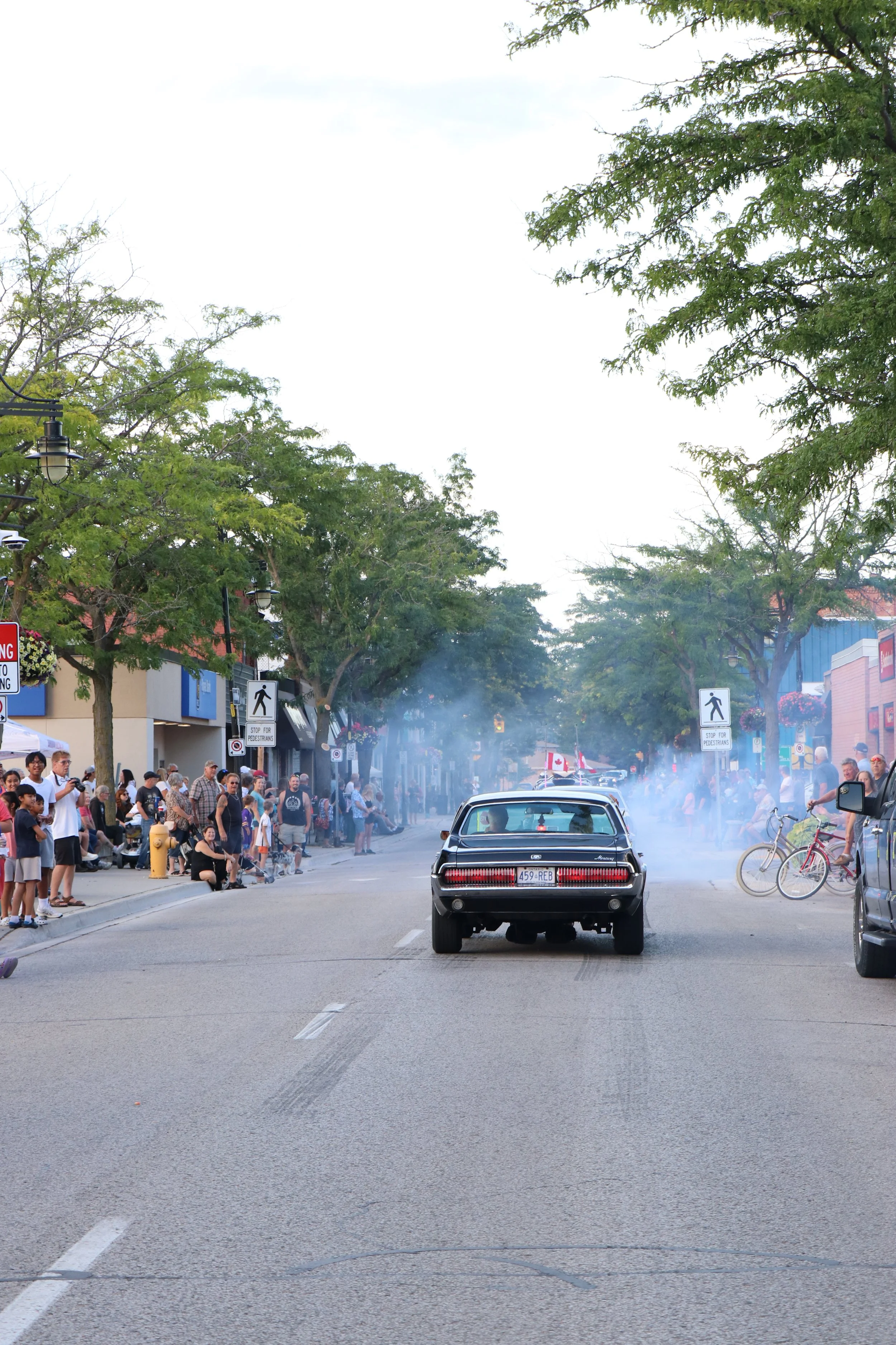 Downtown Wallaceburg street lined with locals and onlookers watching classic cars cruise down the street for the annual Terry Glover Memorial Cruise