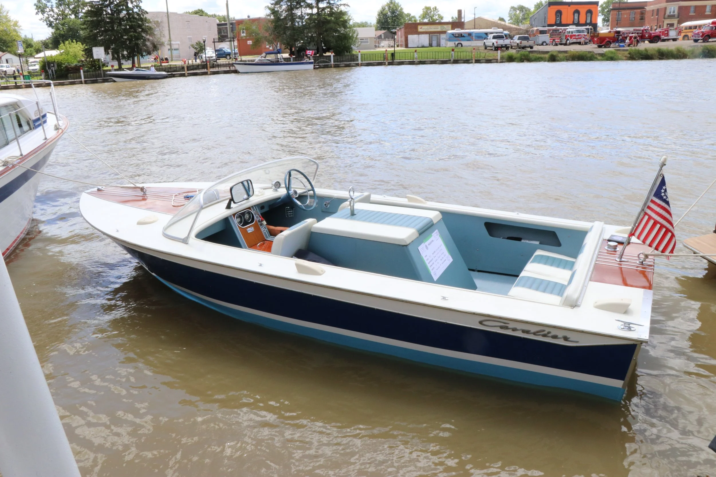 Antique wooden boat with dark and light blue stripes docked on the Sydenham River in Wallaceburg at WAMBO