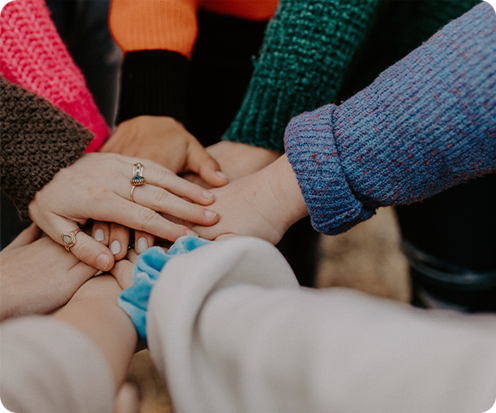 Varias manos de diferentes personas apiladas, mostrando solidaridad y unión.