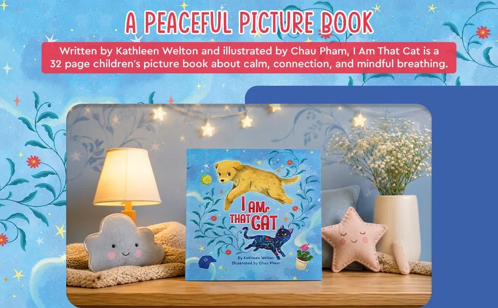 Cover of the children's picture book "I Am That Cat" showing a yellow dog jumping over the title, with a black cat below, against a blue background with stars and plants. The display includes plush toys of a grey cloud with a smiling face, a pink star with a smiling face, and a white flower vase with white flowers.