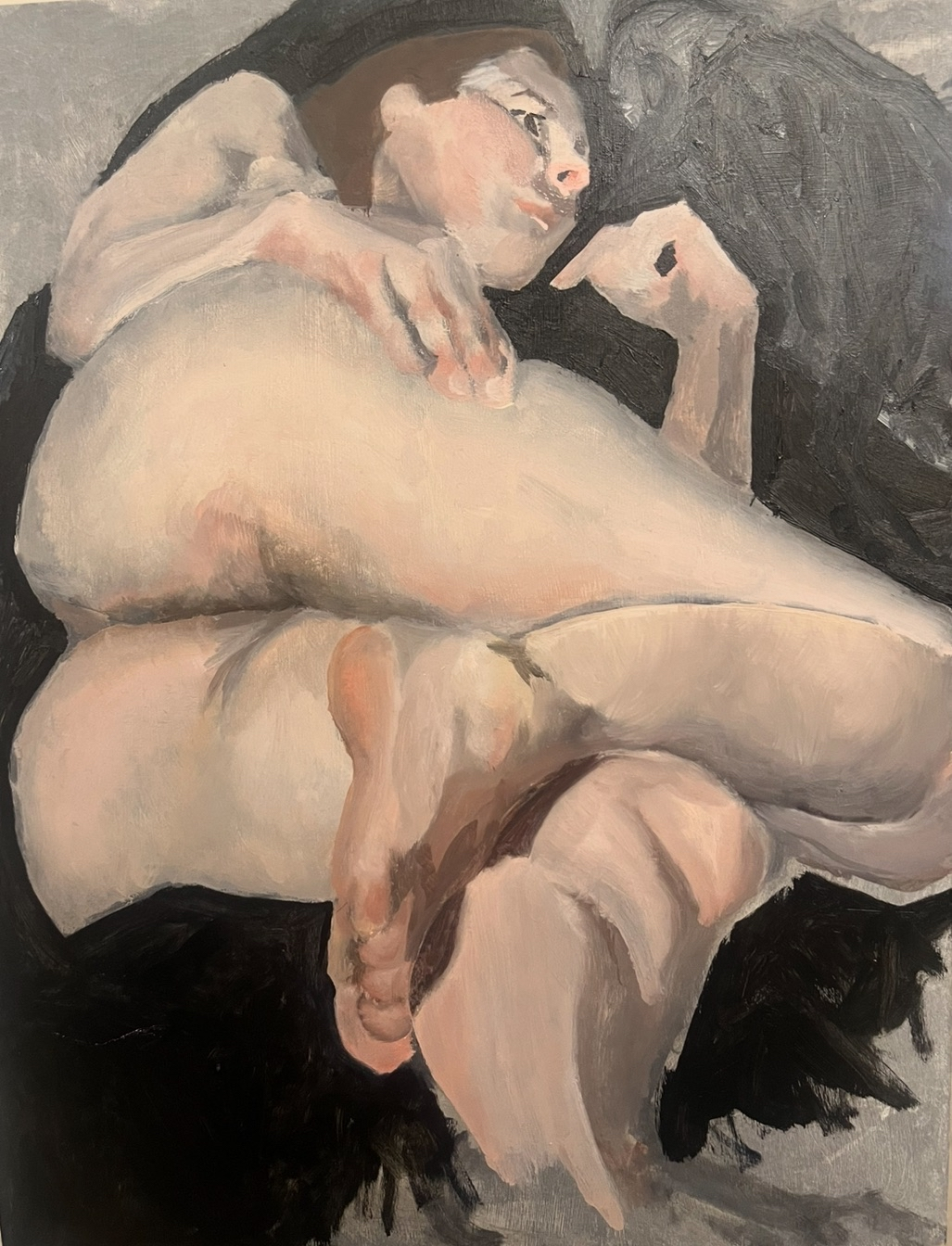 A nude woman with glasses lying on her side on a dark surface, resting her head on her hand, with a contemplative expression.