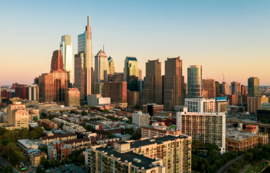 Sunset view of downtown Los Angeles skyline with tall skyscrapers and surrounding buildings.
