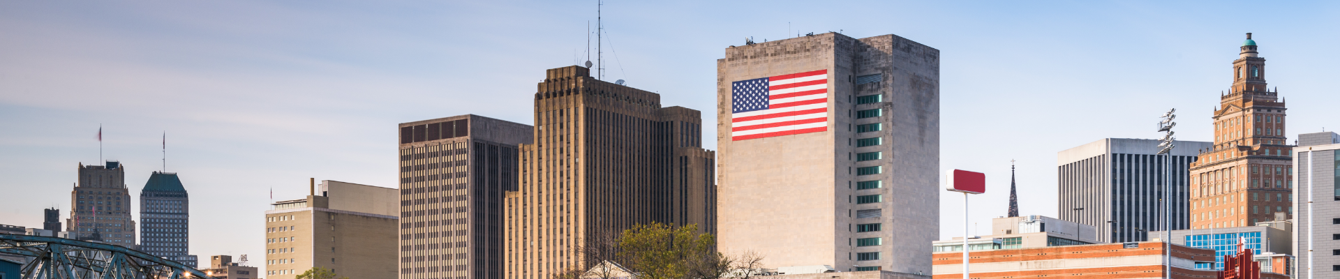 City skyline with a large American flag painted on the side of a building.
