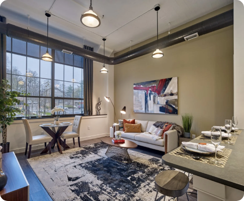 Modern living room with large window, dining area, and contemporary furniture, decorated with colorful artwork and indoor plants.