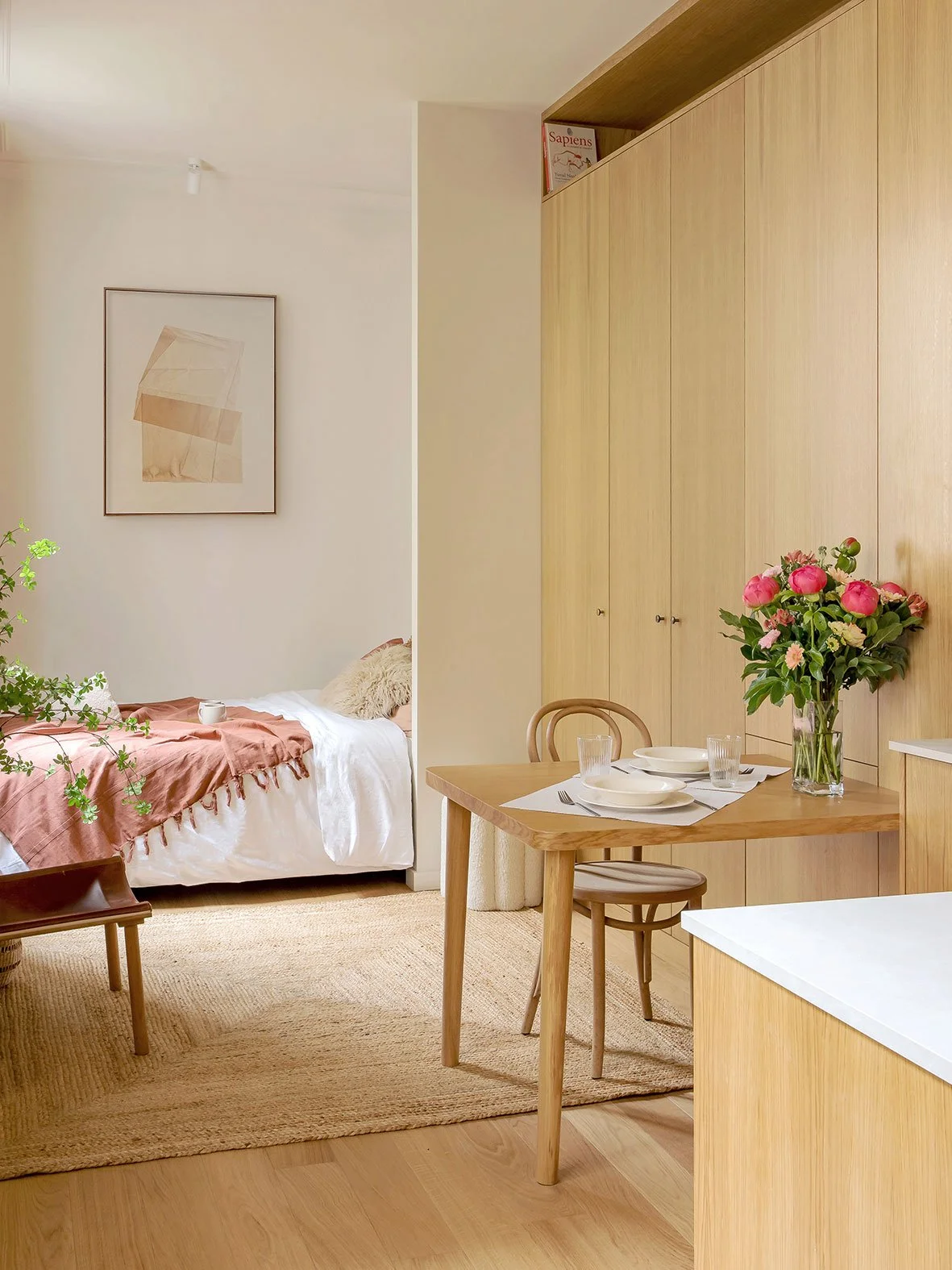 Noa Pariset Architecture d'intérieur - Odéon - Studio de 20 m² - L'espace nuit en fond de perspective ouvert sur l'espace unique qui s'articule autour d'une menuiserie sur-mesure unique et fonctionnelle (dressing, buanderie et rangements multiples.