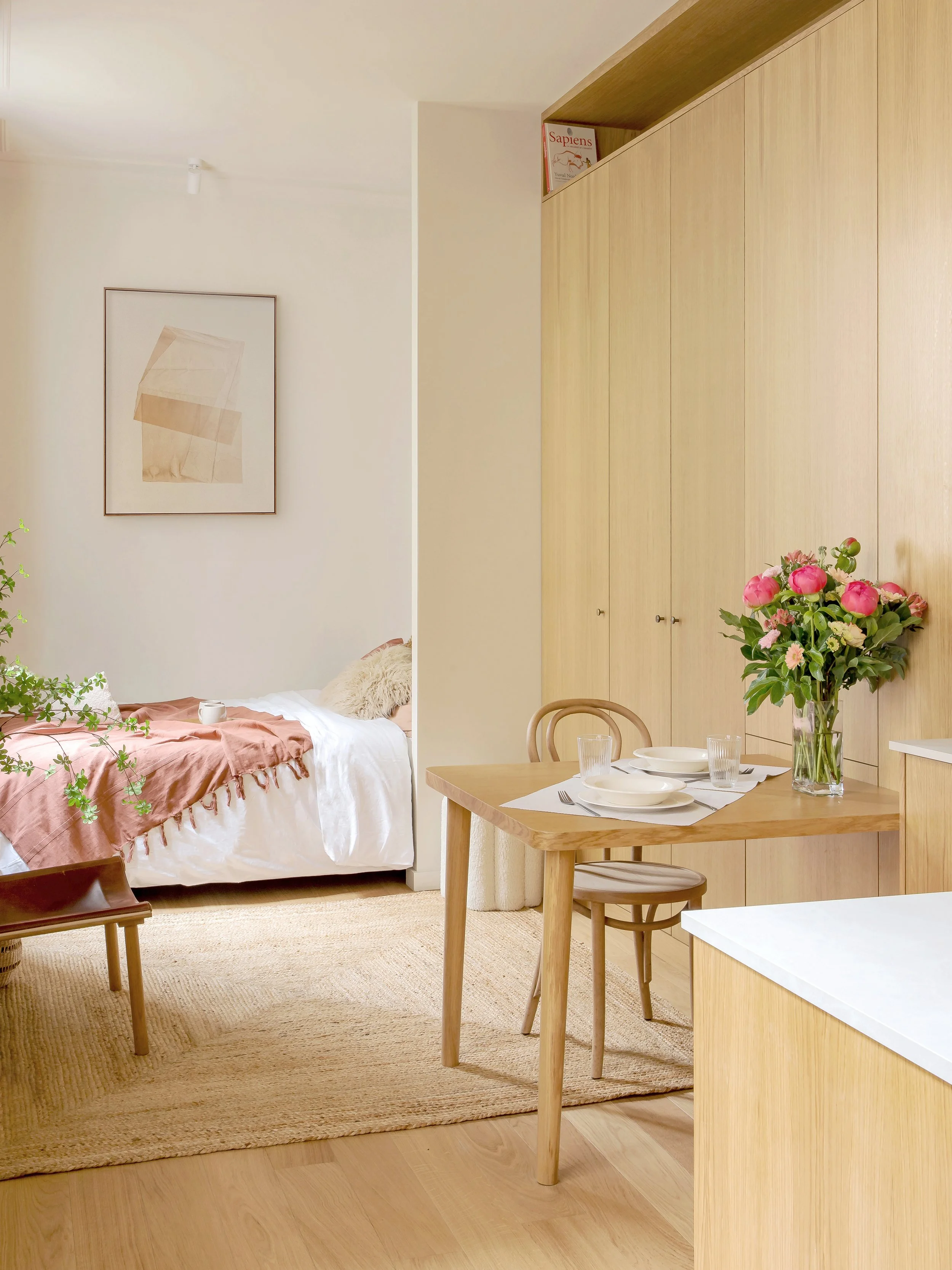 Noa Pariset Architecture d'intérieur - Odéon - Pièce unique ouverte et lumineuse. Studio de 20 m² optimisé et maximisé aux volumes simples et efficaces. Teintes chaleureuses, dressing en bois, agencement fonctionnel.