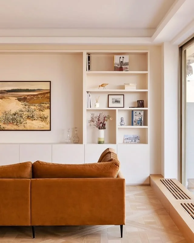 Noa Pariset Architecture d'intérieur - Barrès - En collaboration avec Studio Camille Salzman  - Bibliothèque spacieuse dans un salon avec un canapé ocre - radiateur en plinthe - agencement sur mesure.