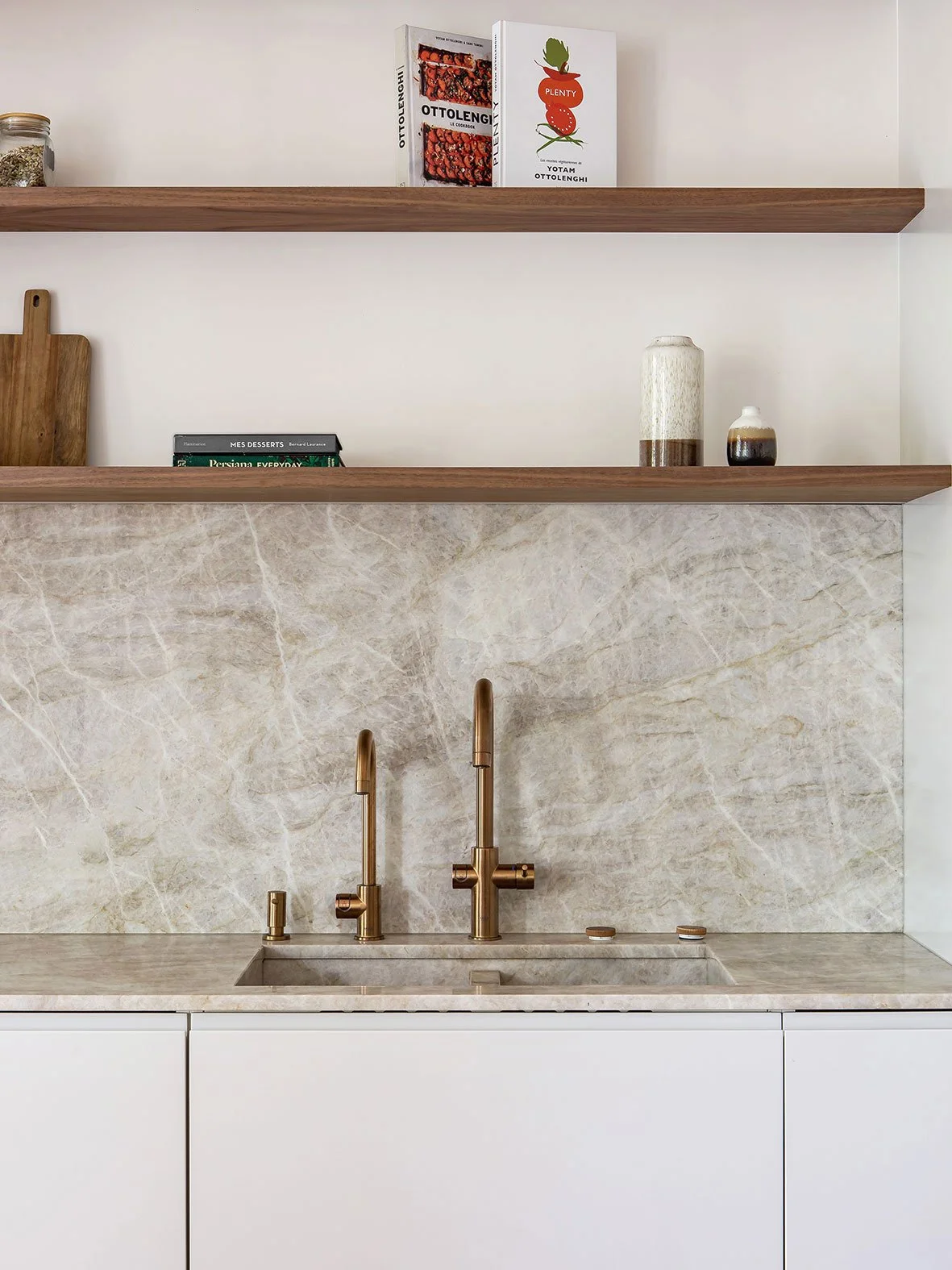 Noa Pariset Architecture d'intérieur - Saint-Michel - Rénovation d'un appartement de 160 m² - Une cuisine épurée qui met en scène des matériaux nobles de qualité. Un plan de travail en céramique TajMahal, des pointes de laiton cuivré et de bois foncé