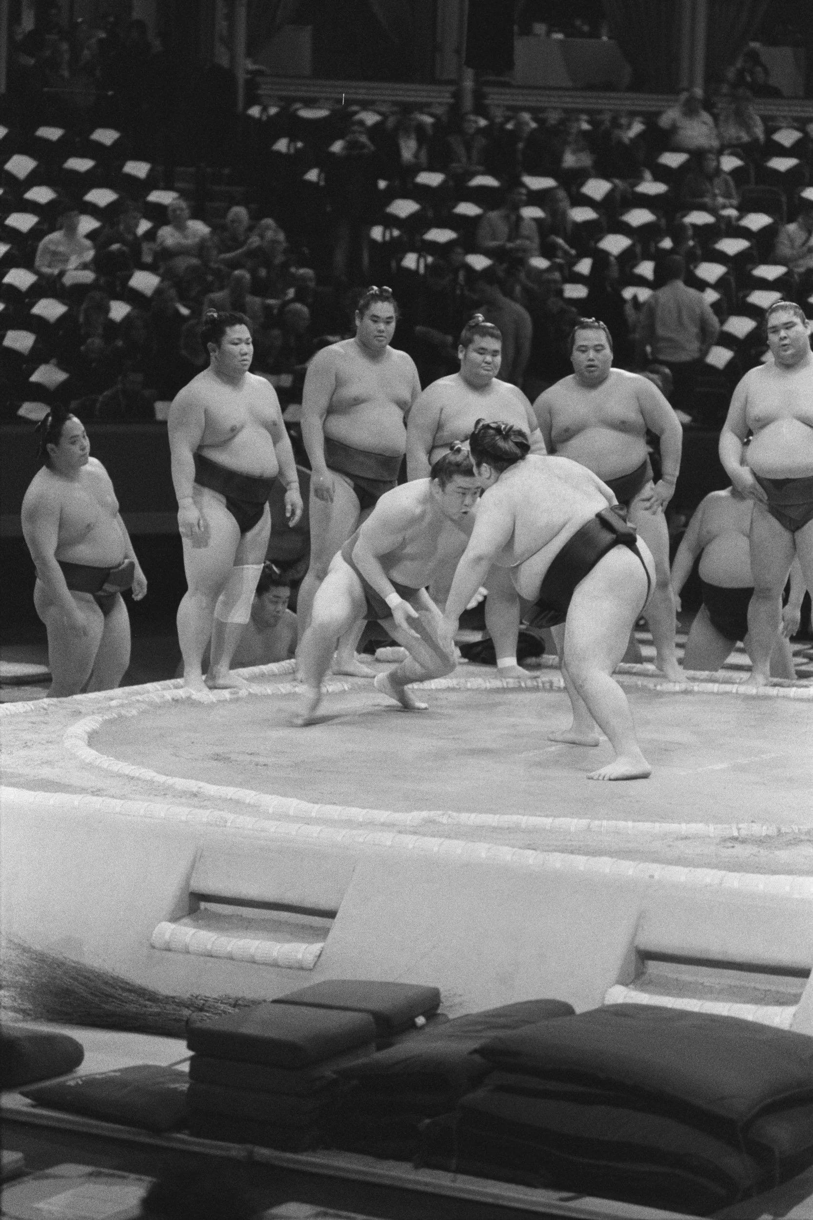 Practice bouts inside a ring of watching wrestlers before the crowd arrives