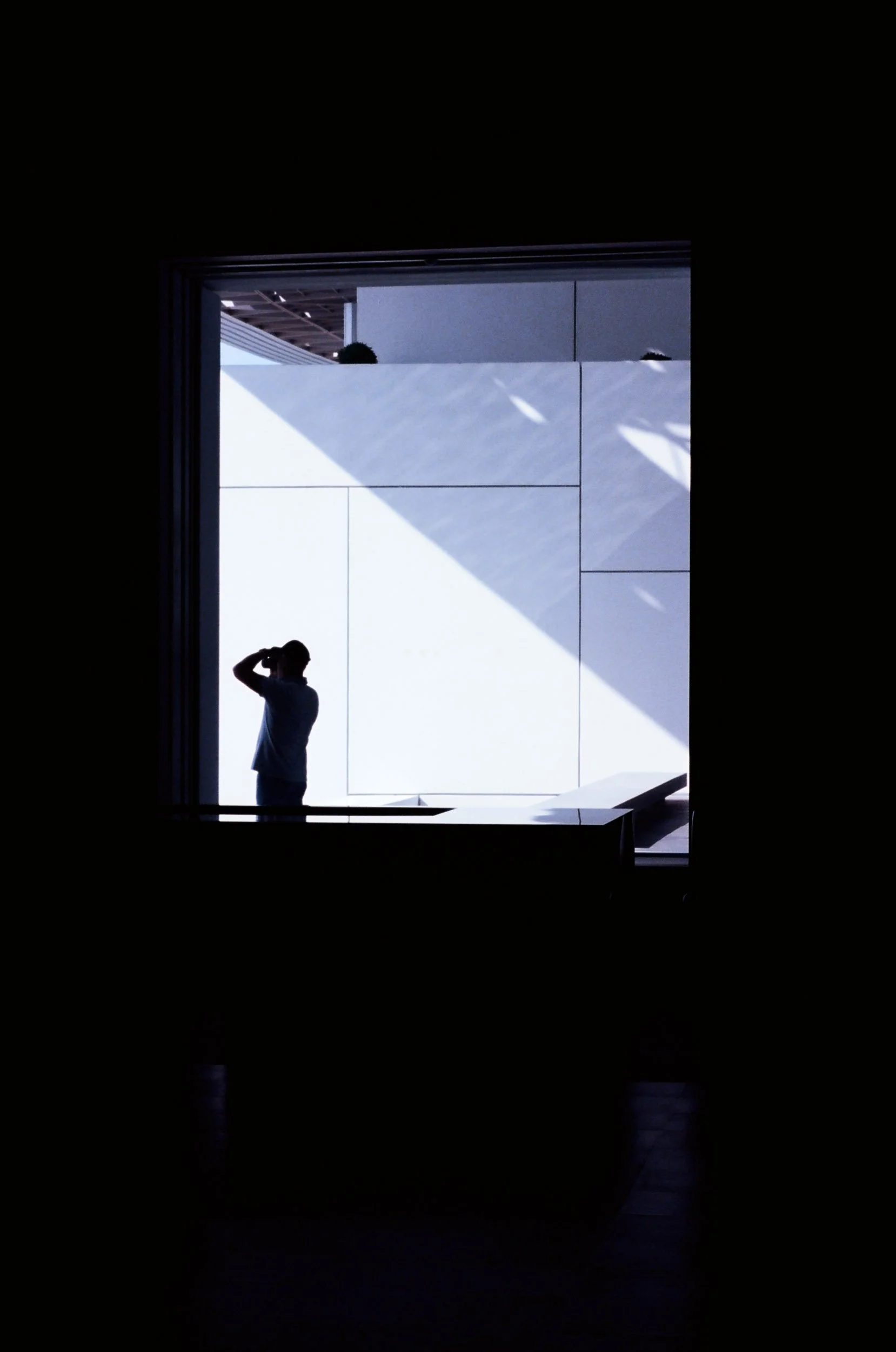 Silhouetted man looking out from a blazing window aperture, Louvre Abu Dhabi