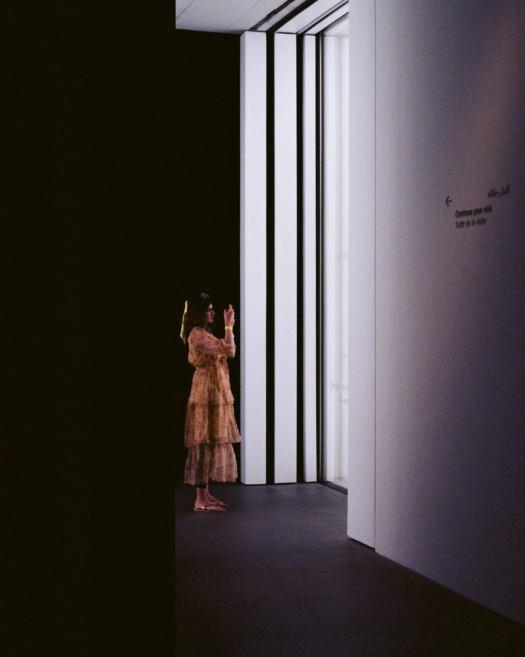 Woman photographing through a lit slatted window