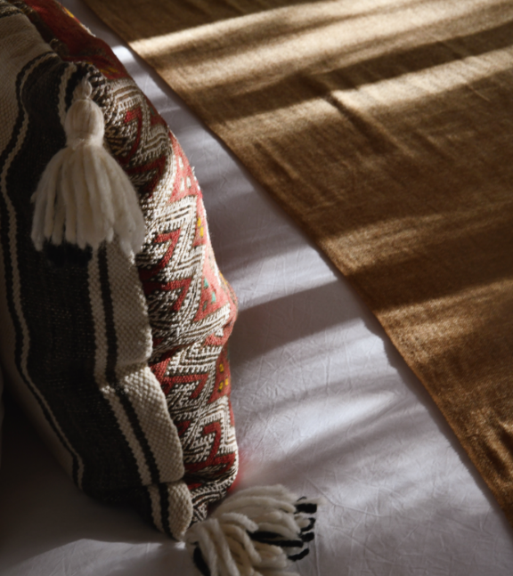 Détail d'un coussin avec motif géométrique et pompon - inspiration maison Beldi.