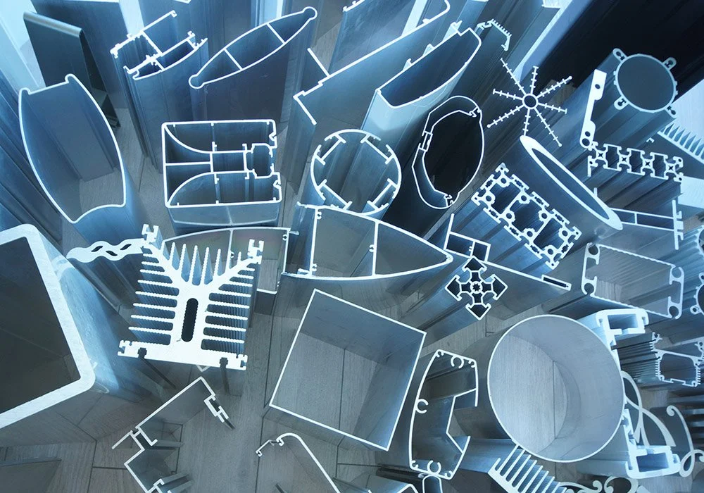 Various metal and plastic parts and frames, possibly components for manufacturing or assembly, arranged on a flat surface.