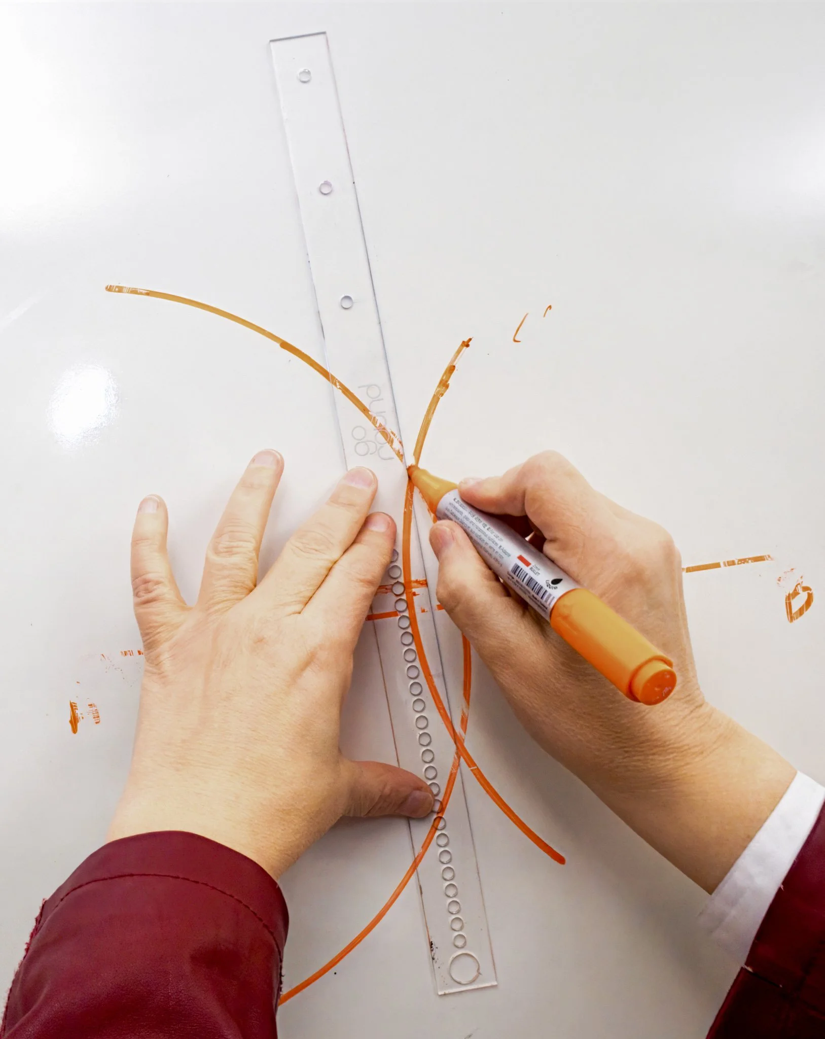 person writing on whiteboard using goround for geometric construction