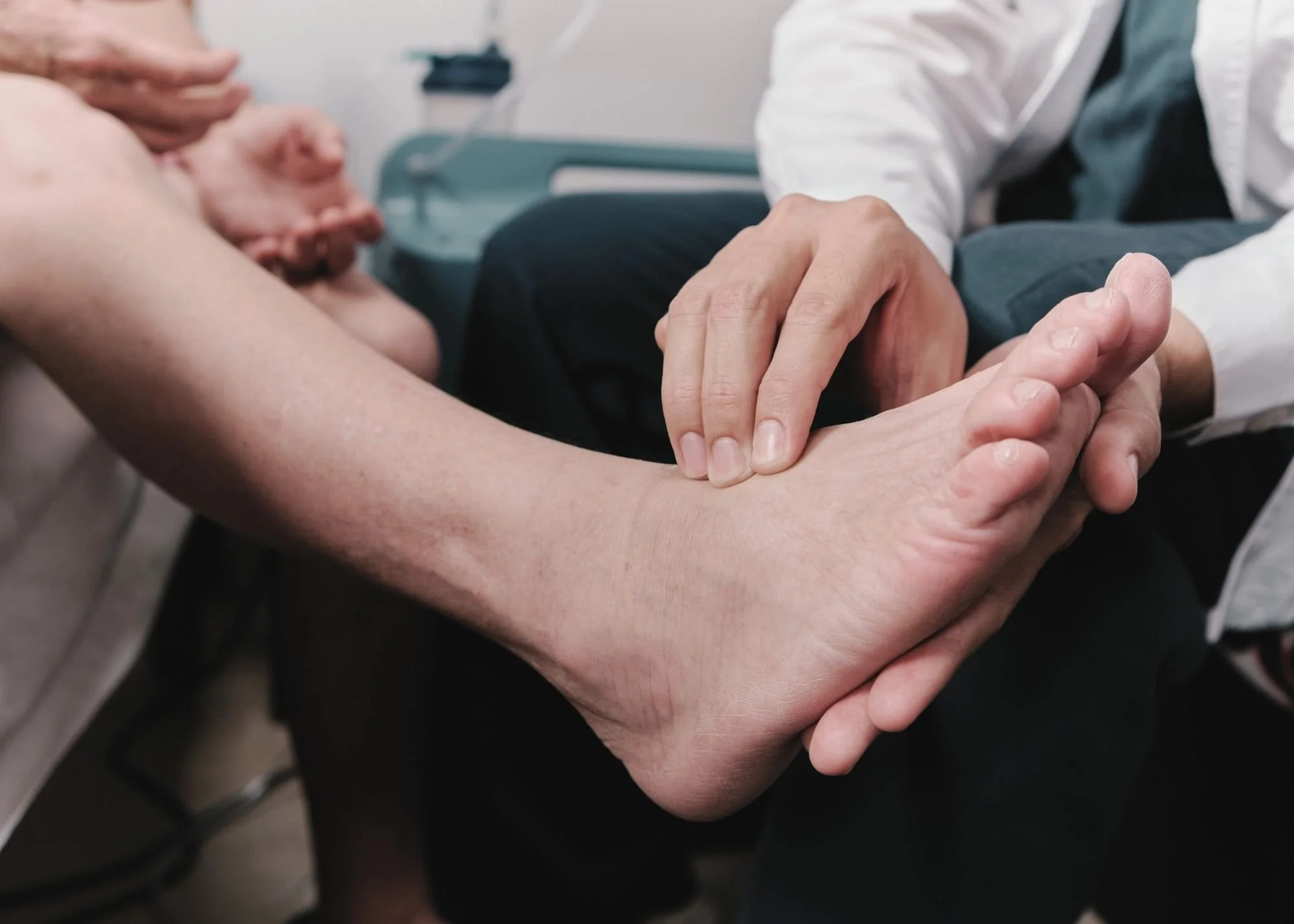 Close-up of a healthcare worker holding a patient's hand during a medical consultation