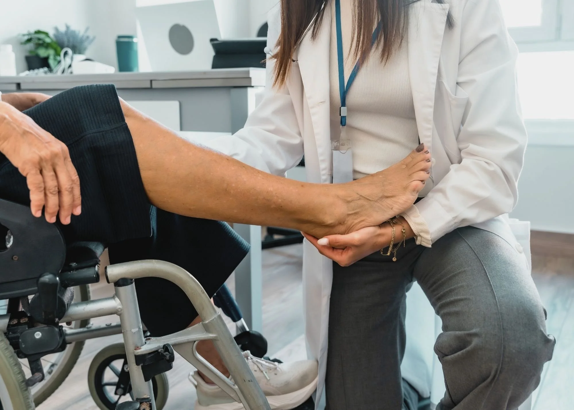 Medical professional examining an elderly person's arm in a healthcare setting.
