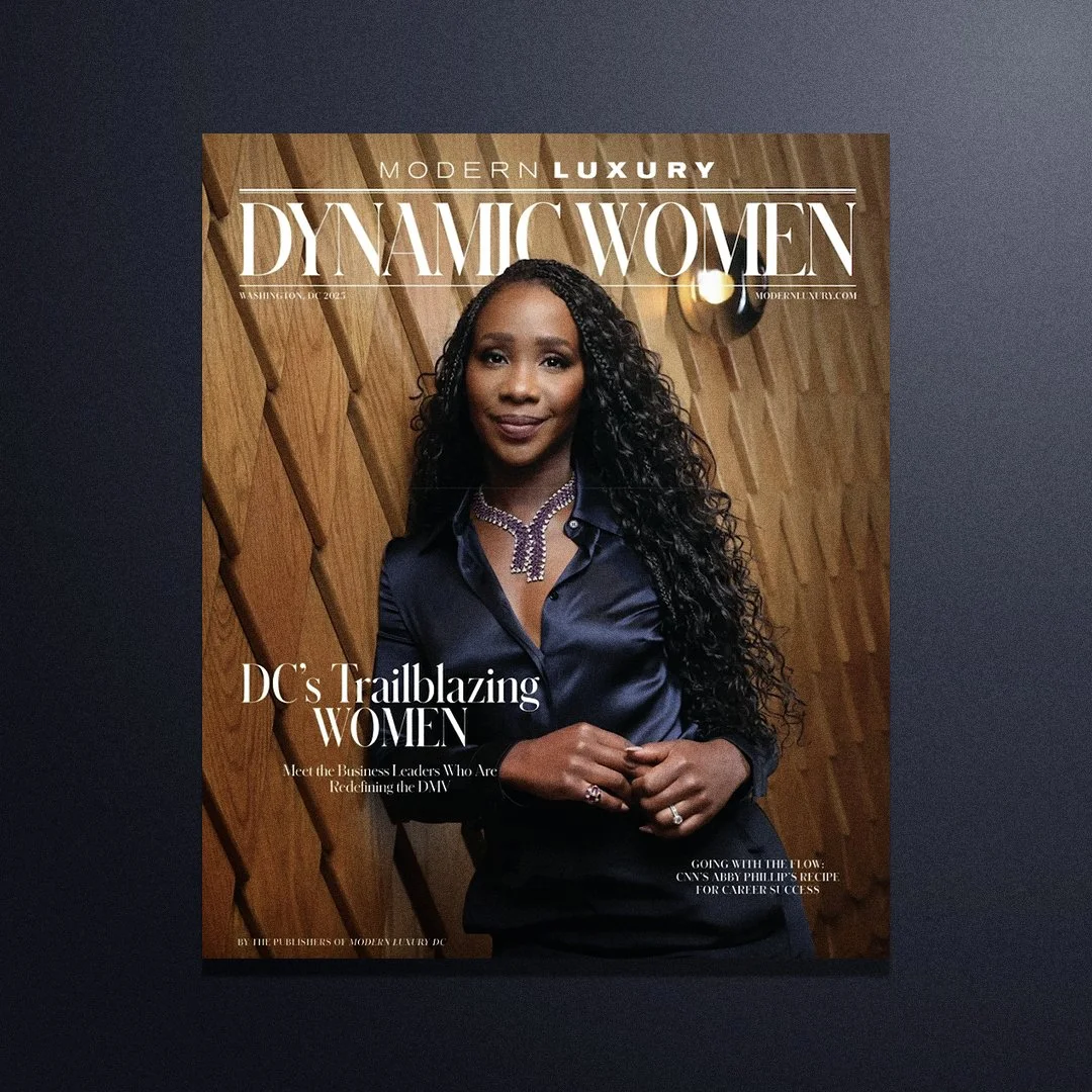 Cover of Modern Luxury Washington DC magazine featuring a woman with long curly hair, wearing a dark satin shirt and jewelry, standing against a wooden wall.