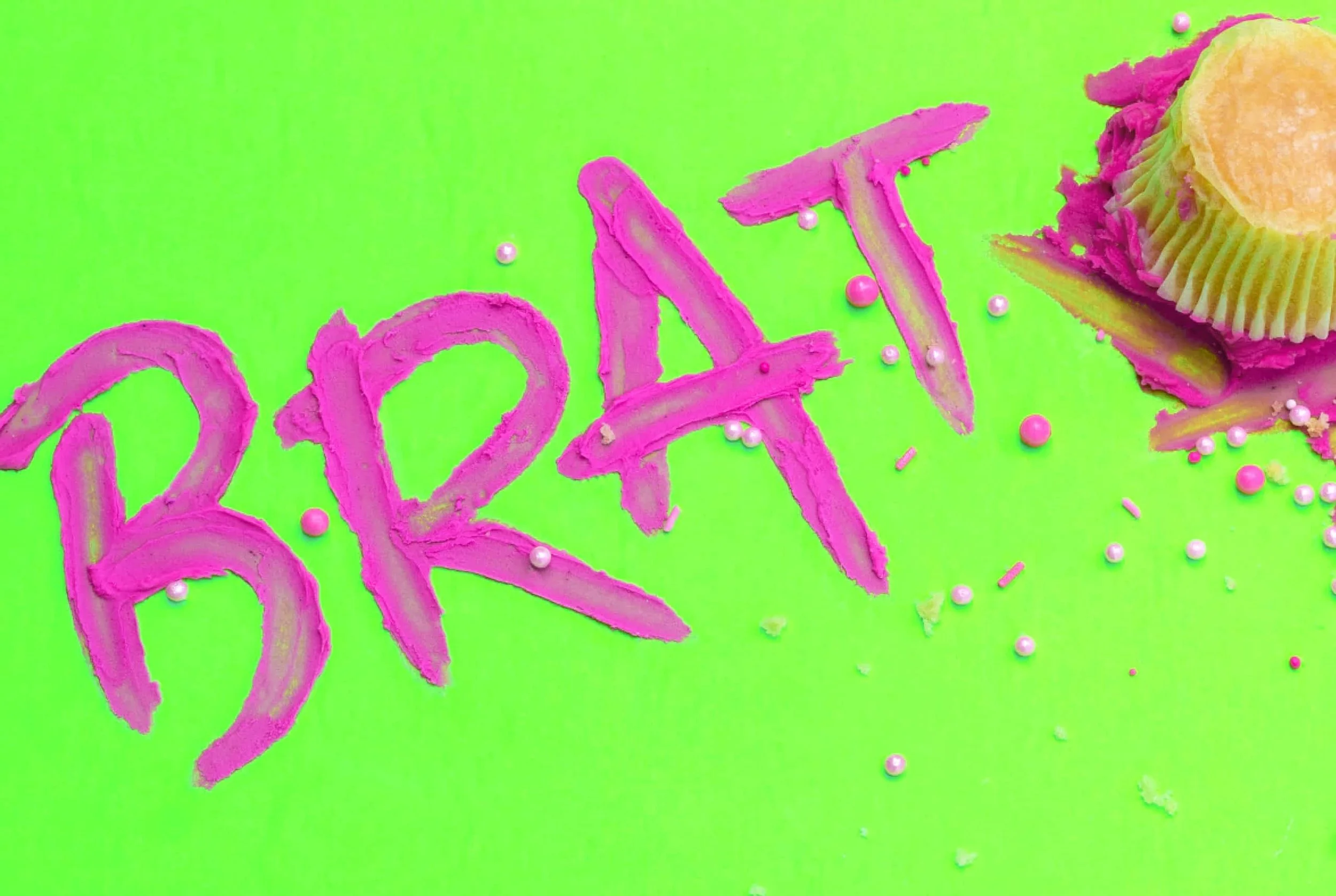 handmade frosting lettering that spells brat next to smashed cupcake art directed photo
