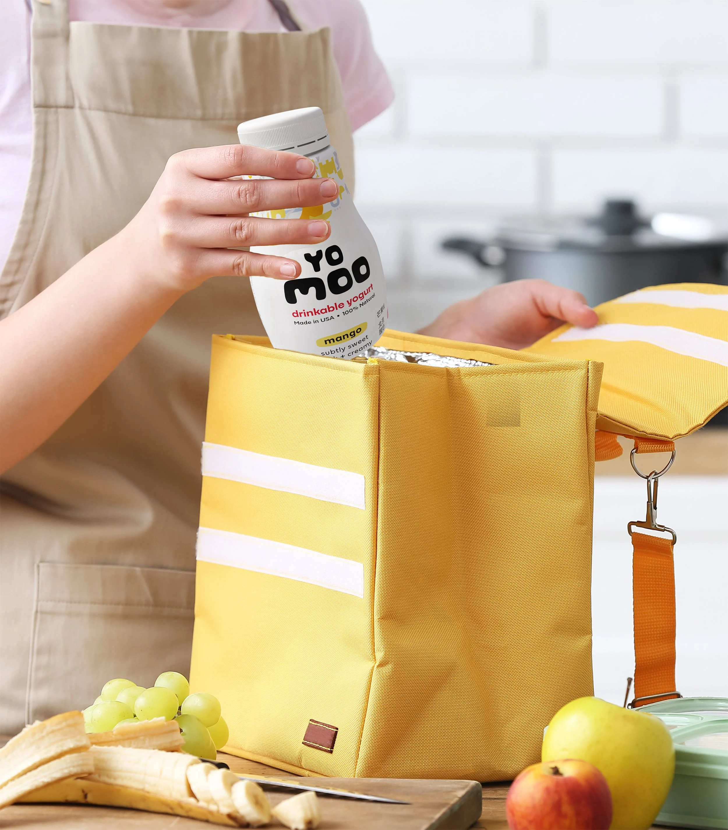 yomoo drinkable yogurt packaging mockup mother placing mango drinkable yogurt into a lunch bag