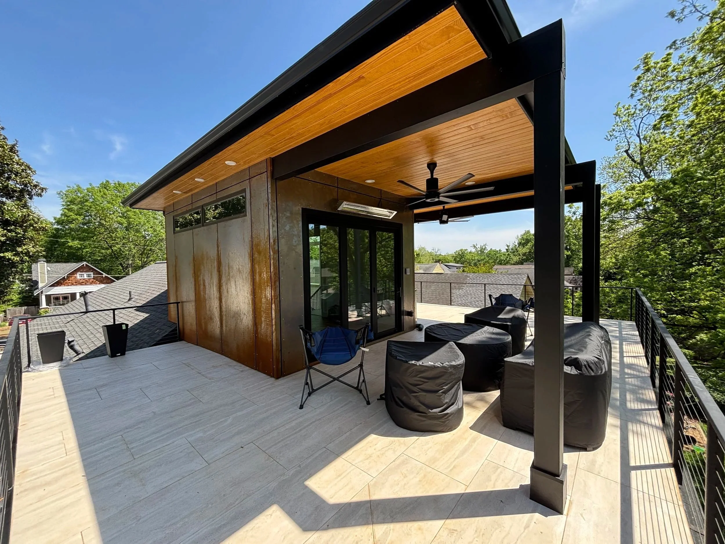 A striking modern second-story addition in Atlanta, GA, featuring structural steel-section wall construction, floor-to-ceiling glass, and contemporary wood accents by Mahfoud Construction Inc.