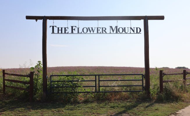 The Flower Mound sign above a gate overlooking the prairie in Flower Mound, Texas