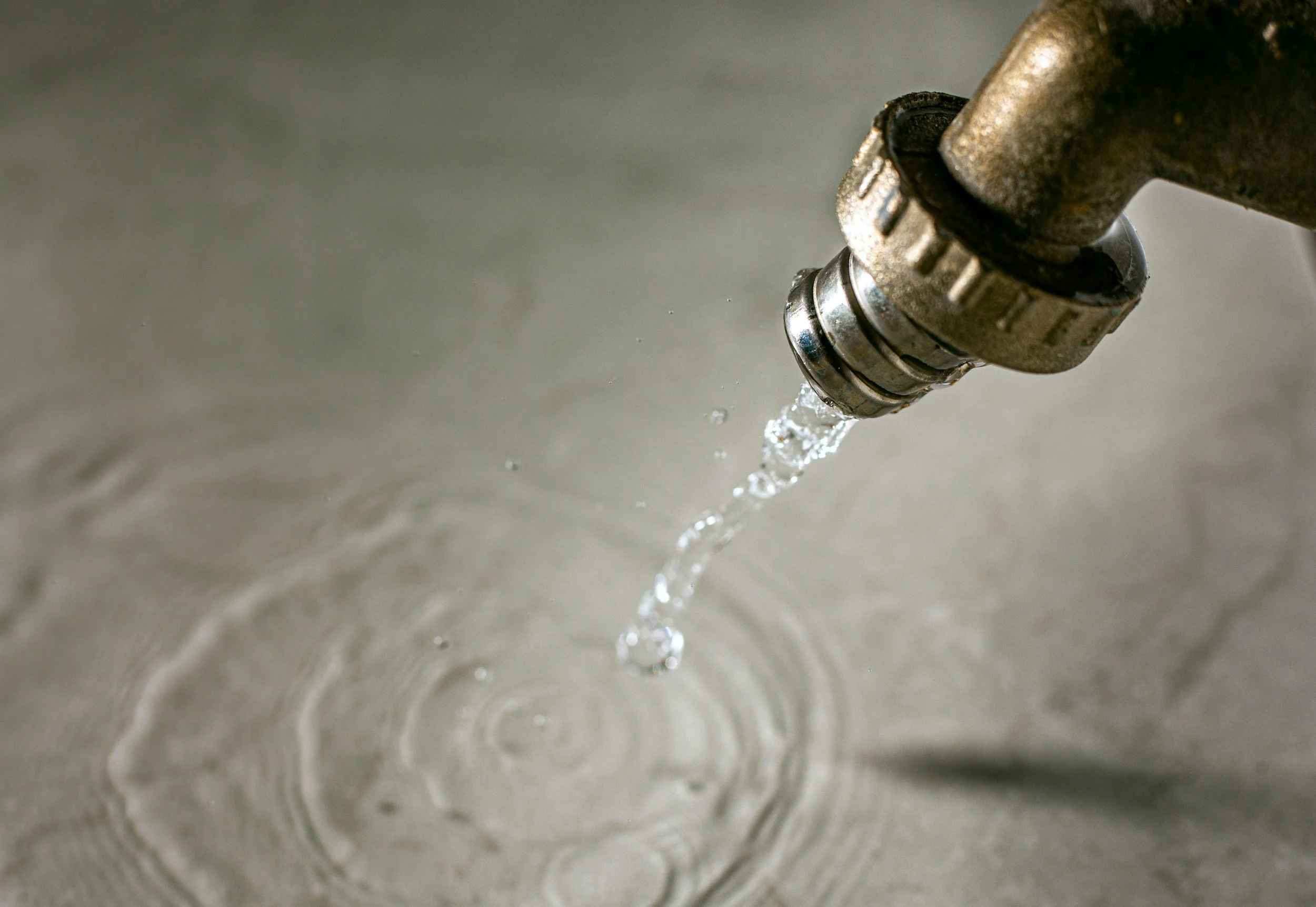 Un robinet en métal qui laisse couler de l'eau dans un évier