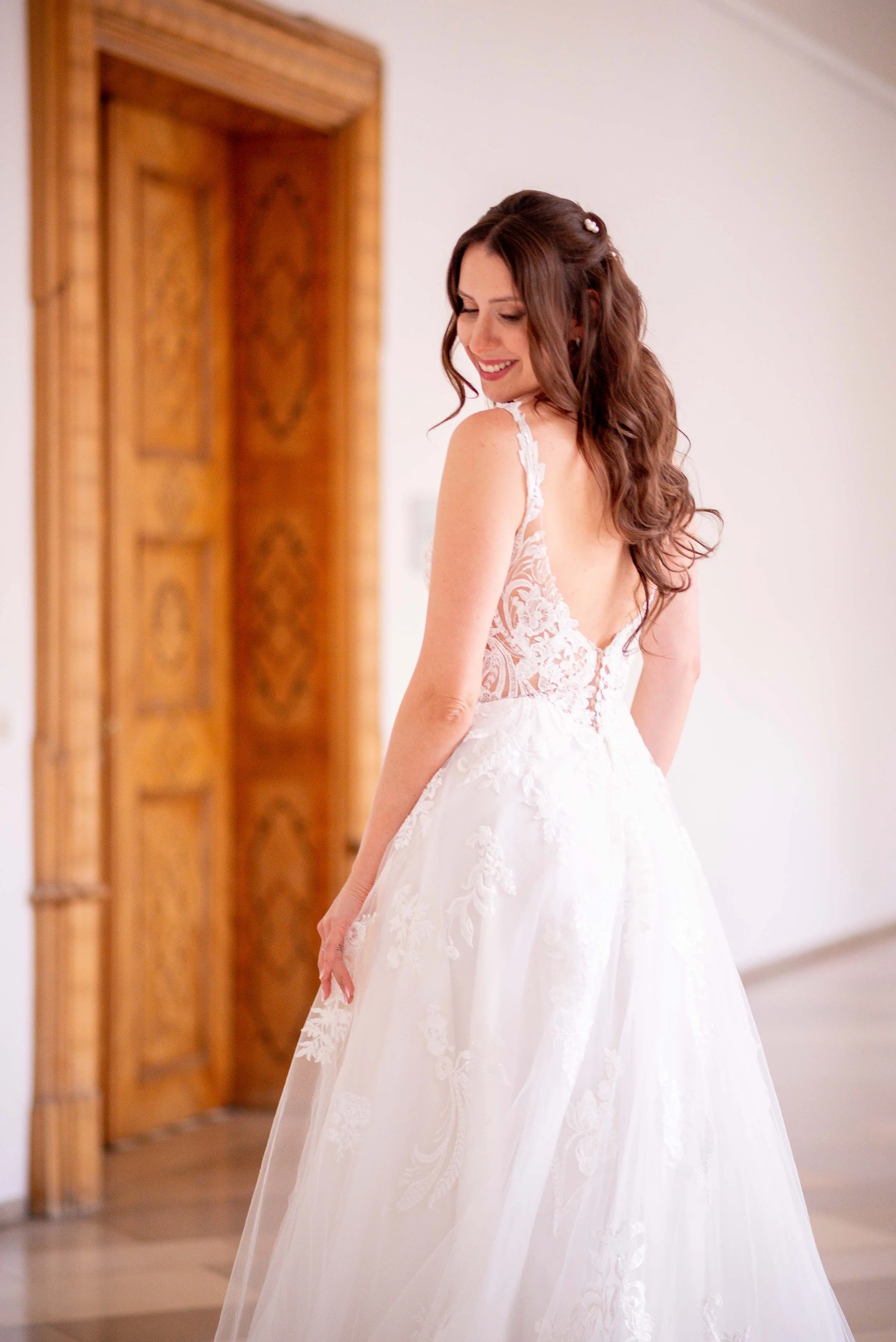 Braut in weißem Hochzeitskleid mit floralen Mustern.