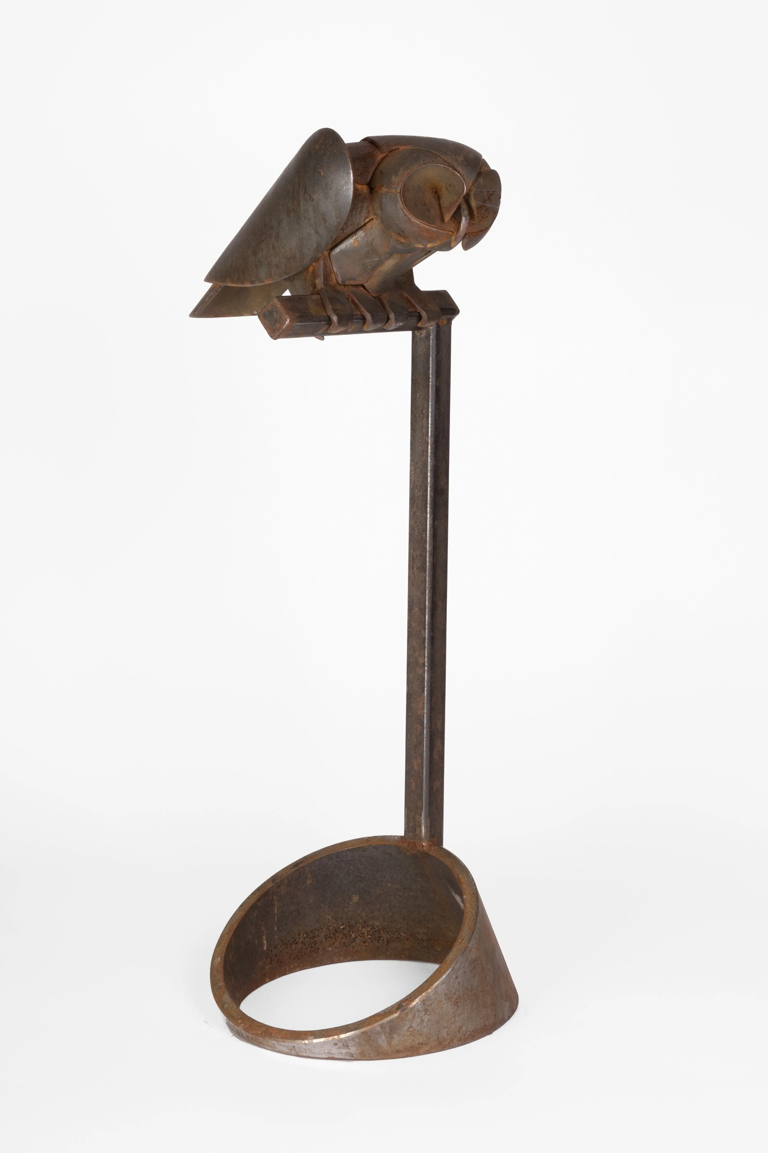 Rusty metal oil lamp with a long vertical chimney and a round base, set against a plain white background.