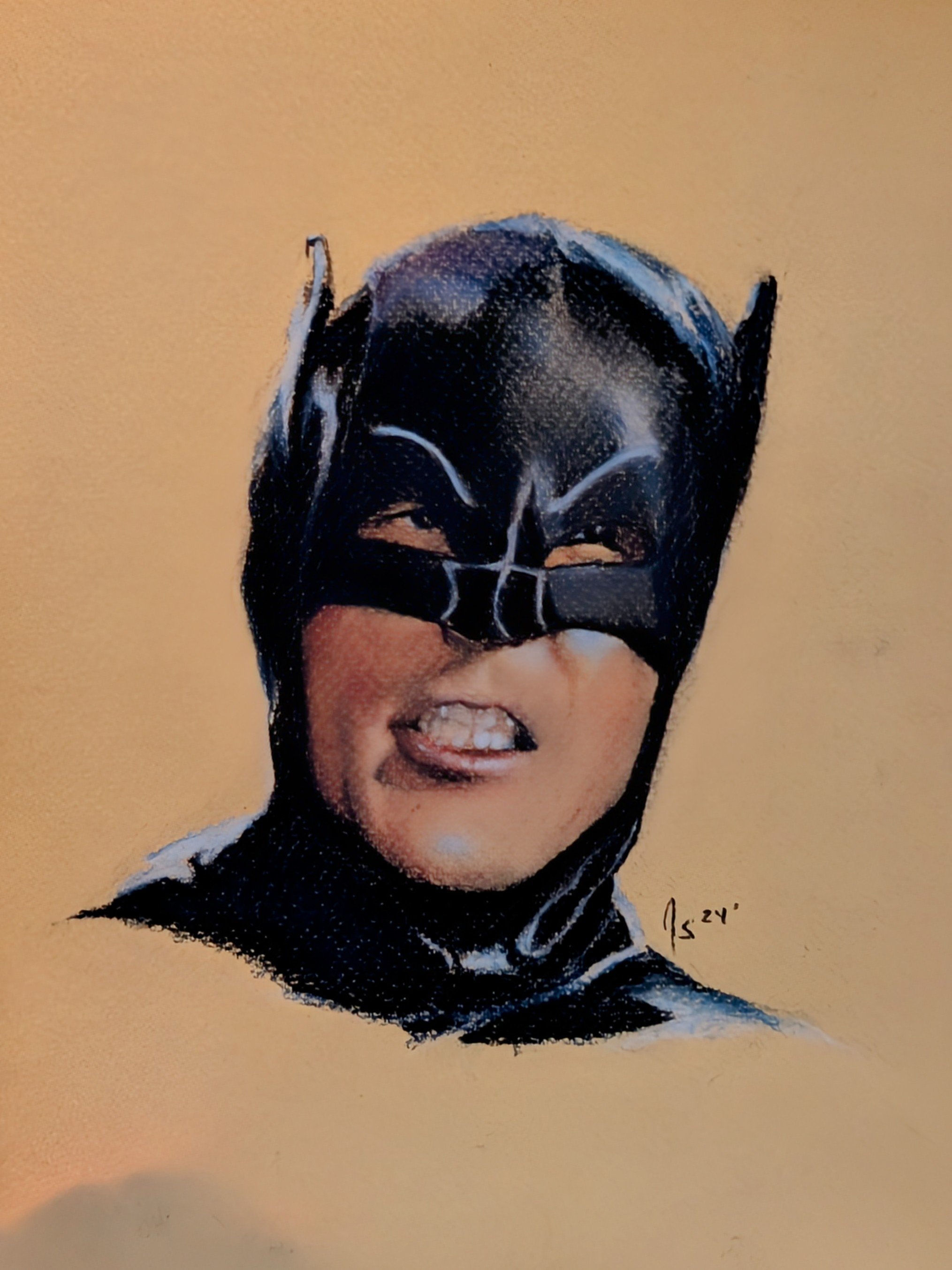 A person wearing a black Batman mask with white accents, showing their face with a playful expression, against a beige background.