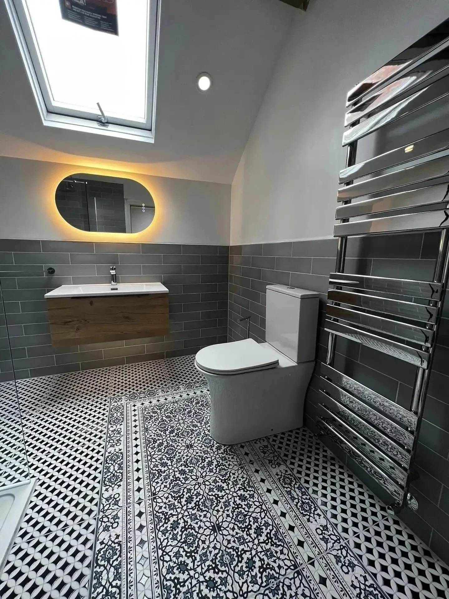 Bespoke bathroom renovation featuring patterned floor tiles and backlit mirror by Stunning Bathrooms in Liverpool
