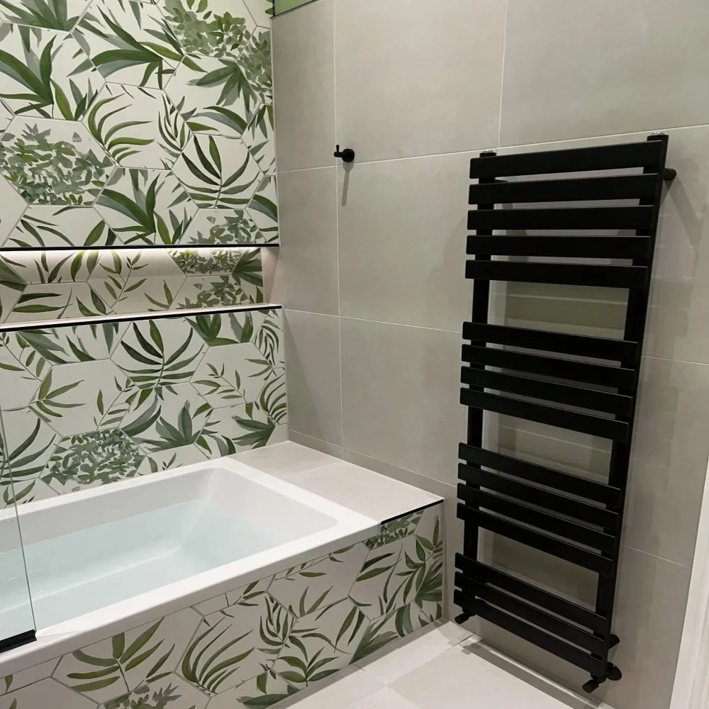 Modern bathroom in Edge Hill with black heated towel rail, leaf pattern feature tiles and built-in bath with LED shelf lighting
