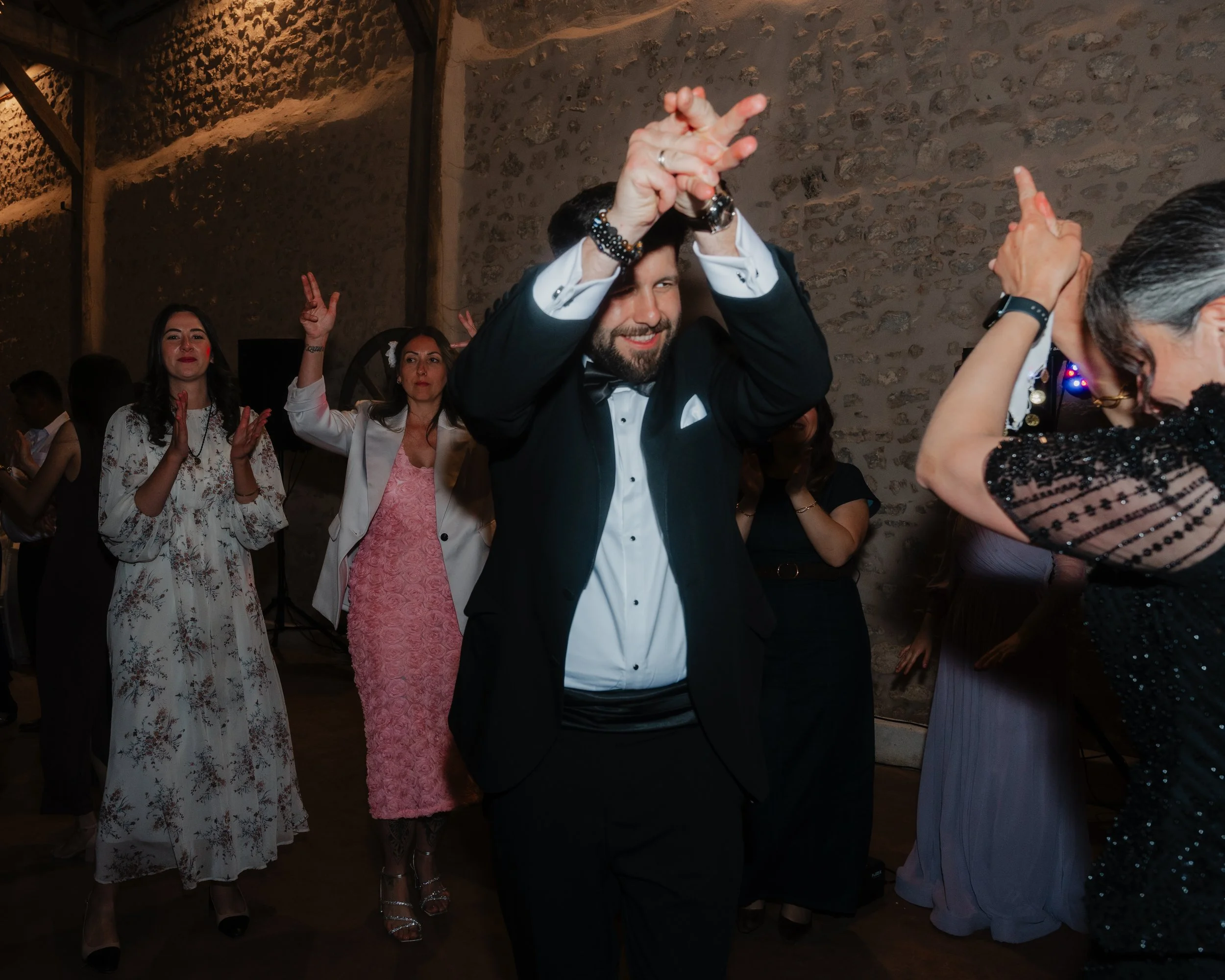 Groupe de personnes dansant lors d'une fête, hommes et femmes habillés élégamment, dans une ambiance chaleureuse
