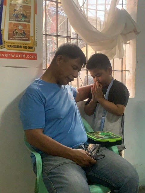 Pastor Rex praying with a child