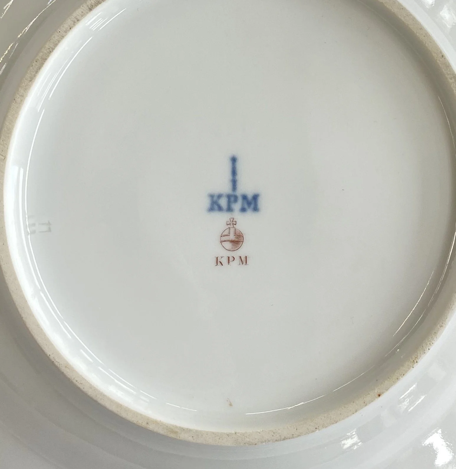 KPM Berlin Teller 03: Unterglasurblaue Zeptermarke mit KPM-Zusatz (1837–1844), roter Aufglasur-Reichsapfel und individuelles Meistersignet P.