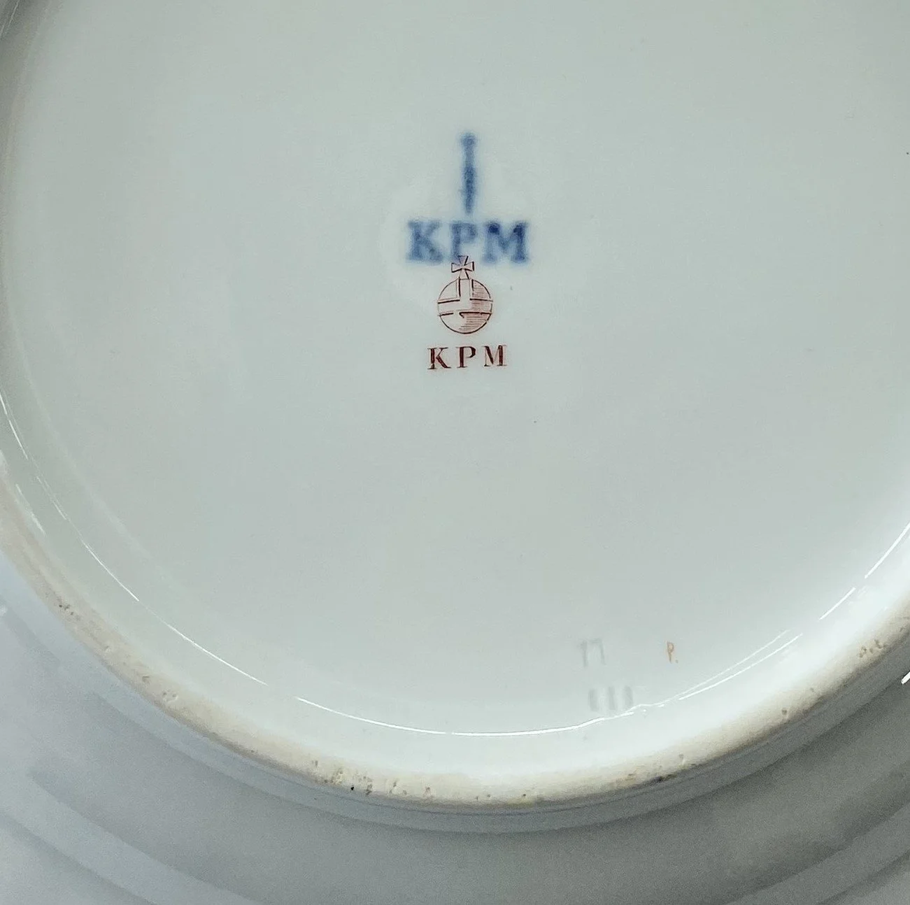 KPM Berlin Bodenmarken (1837–1844): Unterglasurblaue Zeptermarke mit Zusatz KPM, roter Reichsapfel sowie purpurrotes Aufglasur-Malersignet P. und Preßmarken.