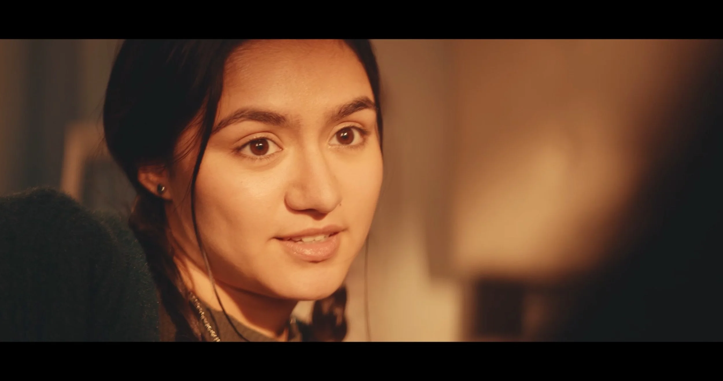 A young woman with dark hair and brown eyes looking at the camera with a neutral expression.