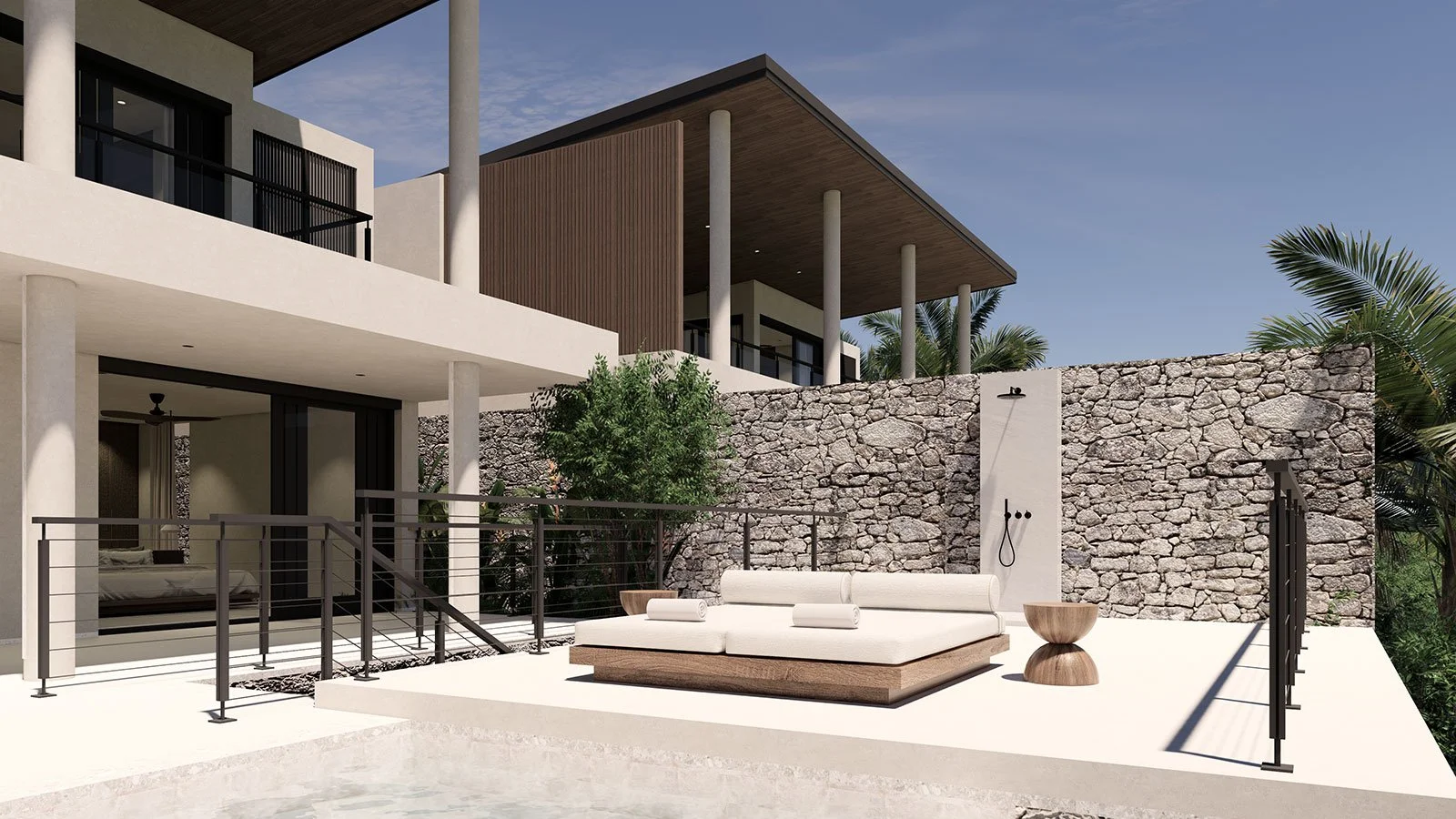 Modern multi-story house with outdoor patio, stone wall, cushioned lounge seat, small wooden side table, and lush greenery in the background.