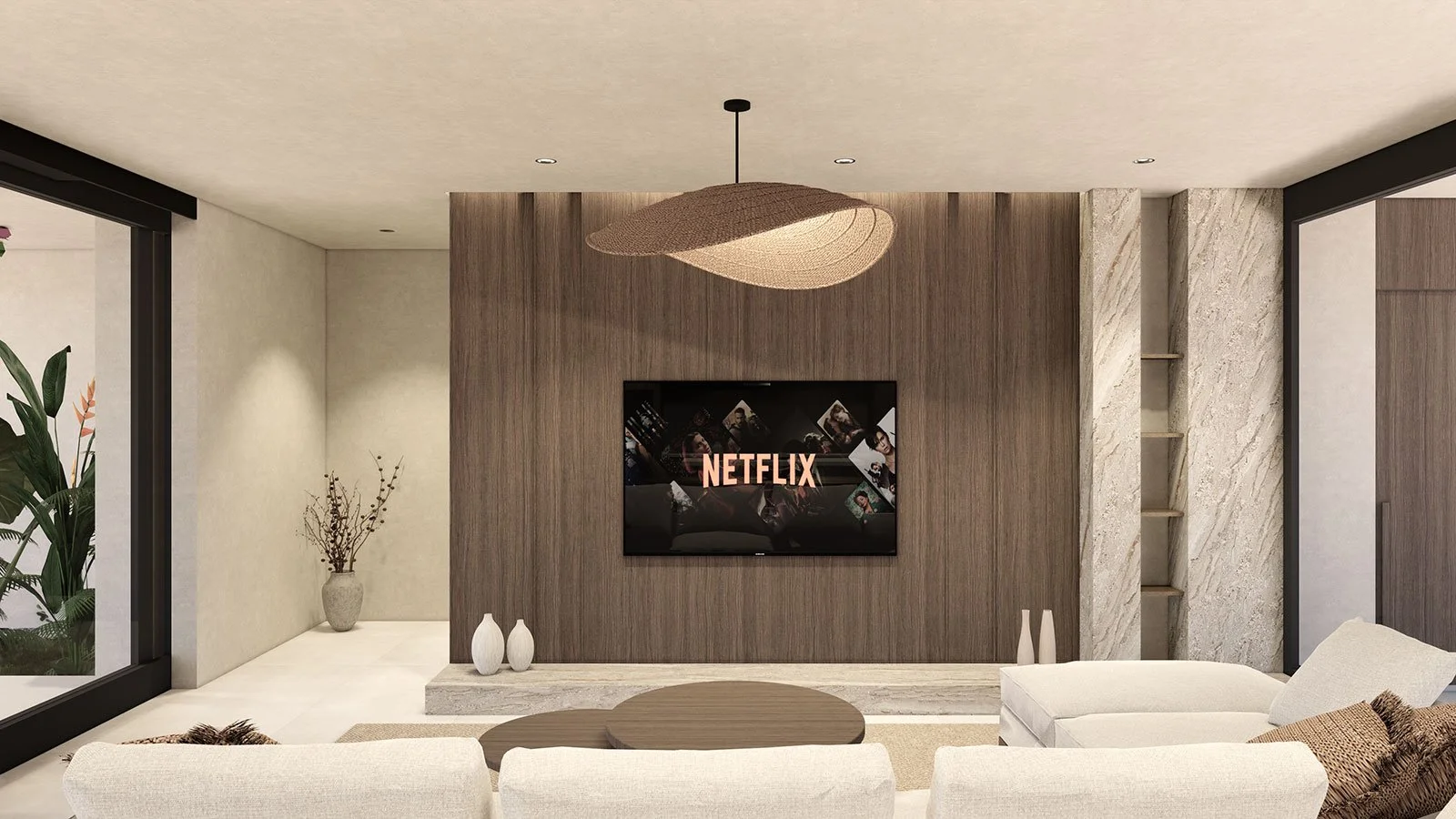 Modern living room with a wall-mounted Netflix screen, white couch, round coffee table, decorative vases, a large ceiling light, and a floor-to-ceiling window with a view of outdoor plants.