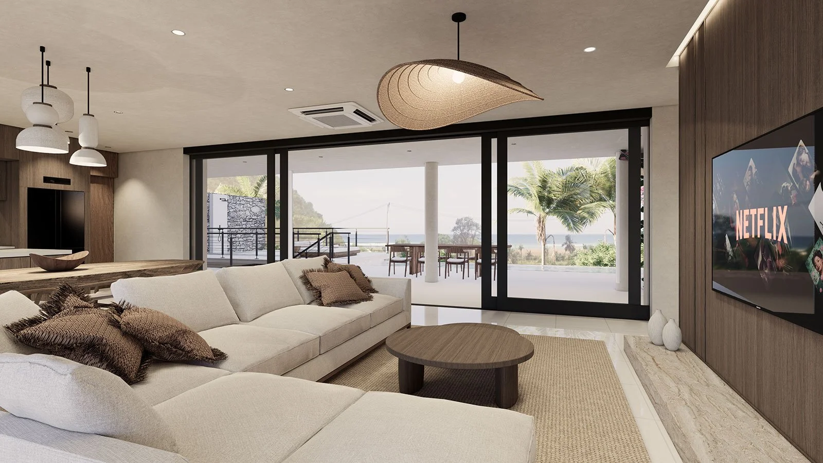 Modern living room with beige sectional sofa, brown cushions, and wooden coffee table, large sliding glass doors leading to outdoor patio with dining table and chairs, view of palm trees and ocean, flat-screen TV with Netflix logo, ceiling lights, an