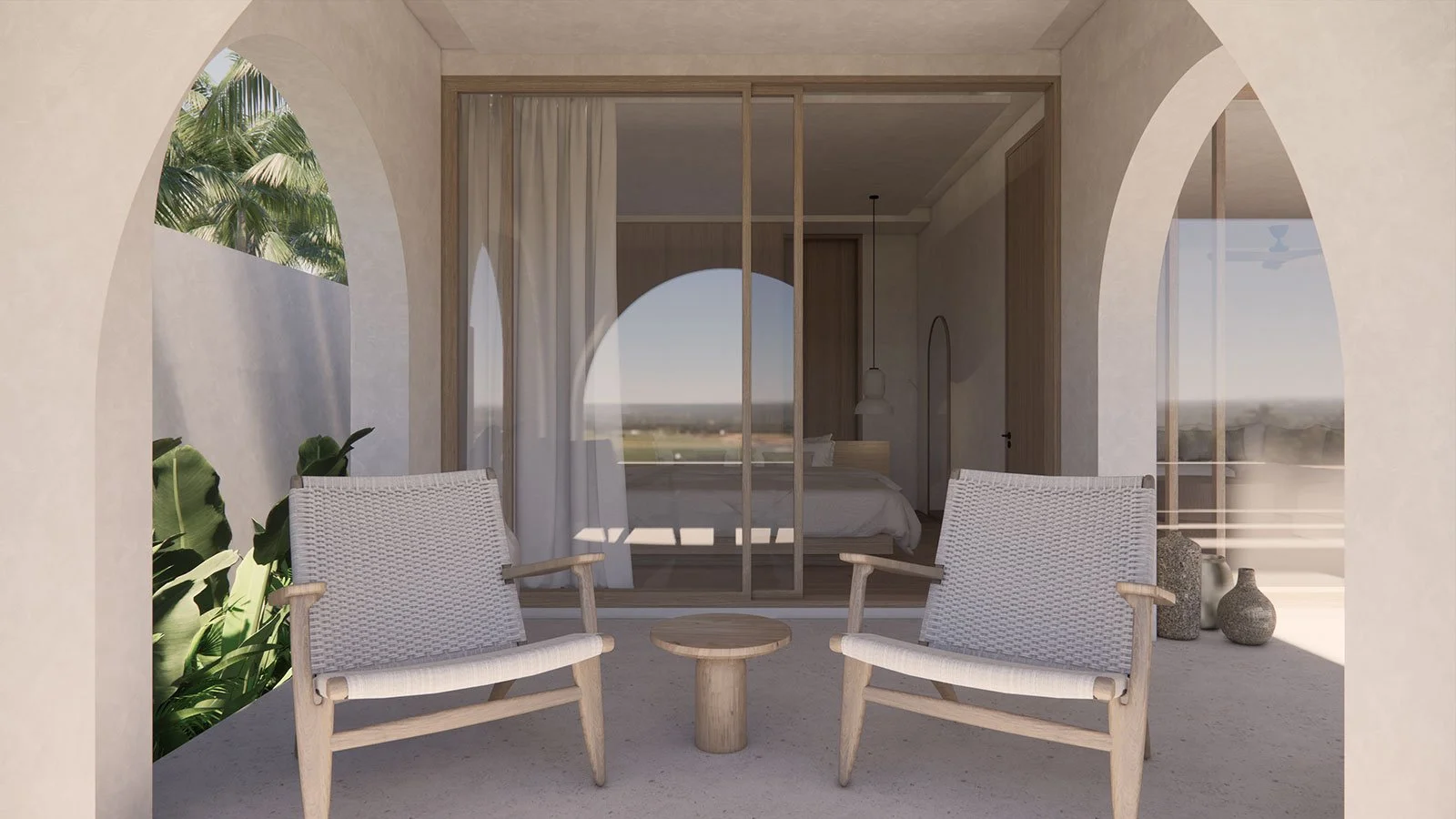 Outdoor patio with two beige woven chairs and a small round table, overlooking a bedroom through sliding glass doors, with decorative vases, lush green plants, and a tropical view.