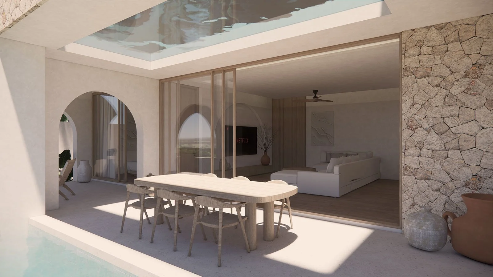 Modern outdoor patio with a dining table and chairs, adjacent to a living room with a sofa, TV, and a stone accent wall."