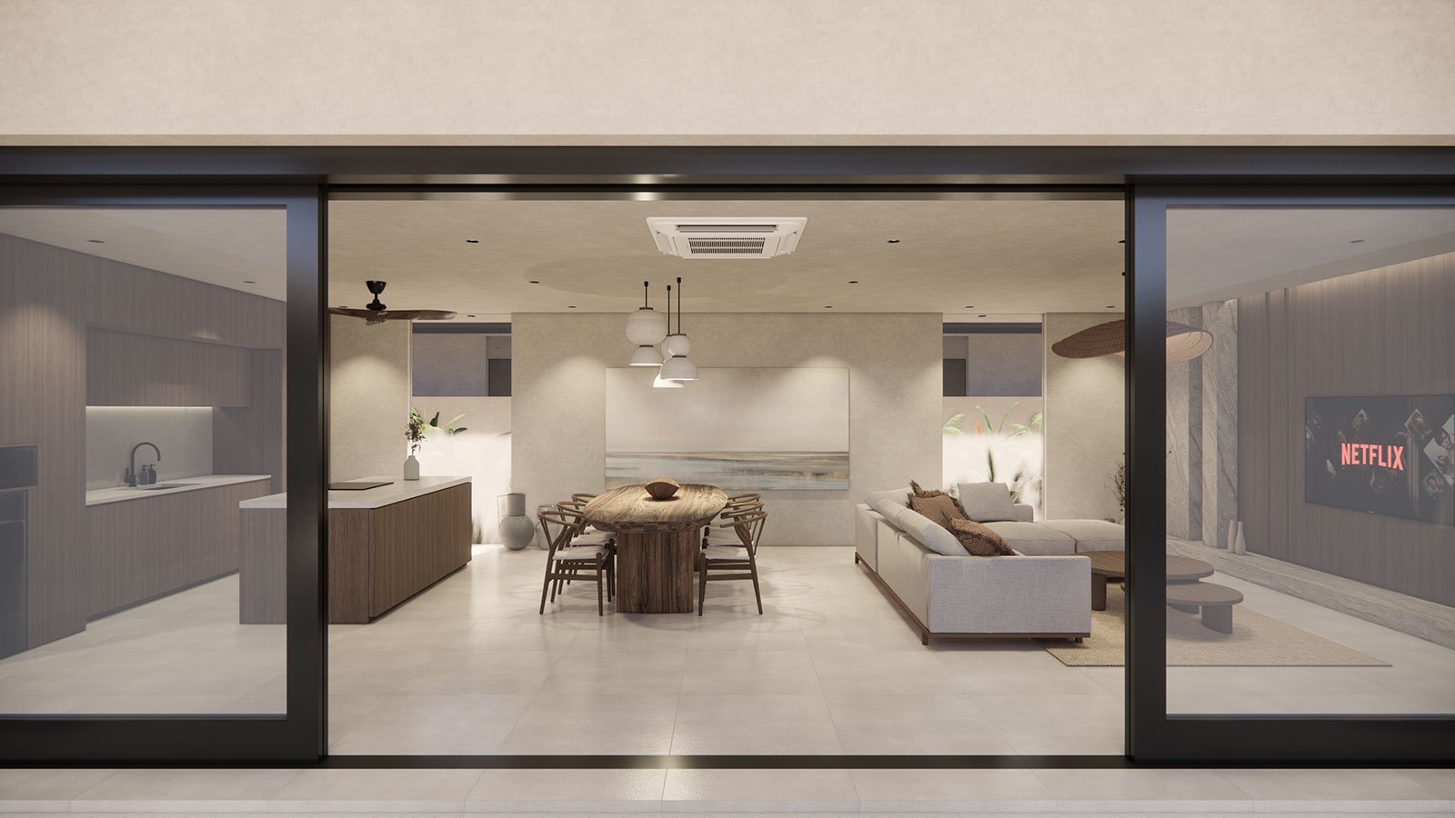 Modern living room with a dining area, beige sofa, wall-mounted Netflix TV, and open kitchen with white cabinets, viewed through sliding glass doors.